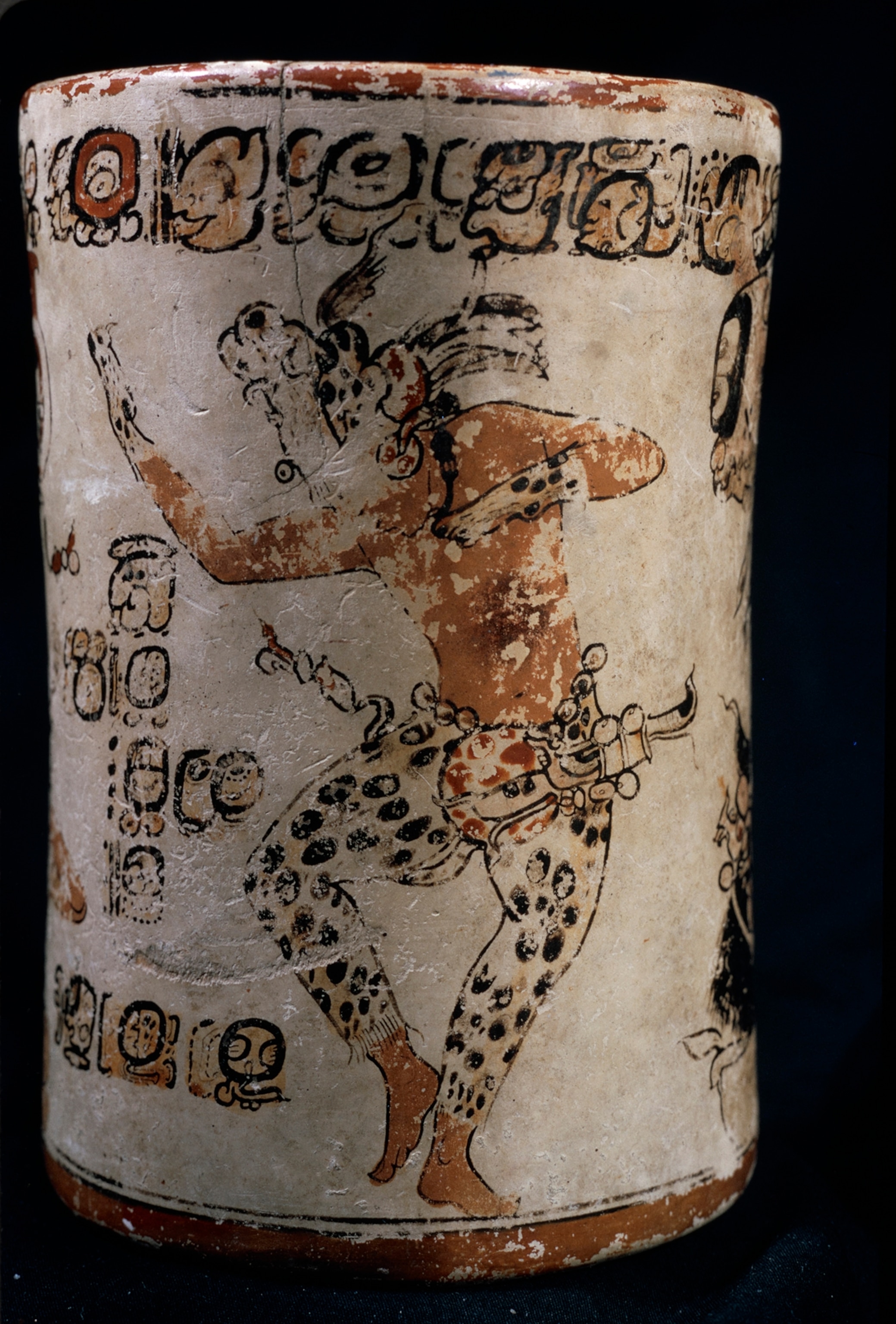 Ceremony of self-sacrifice unfolds on an exquisite Maya vase, buried with a young woman at Altar de Sacrificios, Guatemala. Jade inlays in her teeth identified her as an aristocrat; she evidently died to accompany an older noblewoman, buried below her. The vase bears glyphs that date the suicide to April 21, 754, and identify the participants. The male dancer, in jaguar-skin headdress, mittens, and trousers to impersonate the god of the underworld, is the renowned ruler of Yaxchilin, Bird Jaguar.