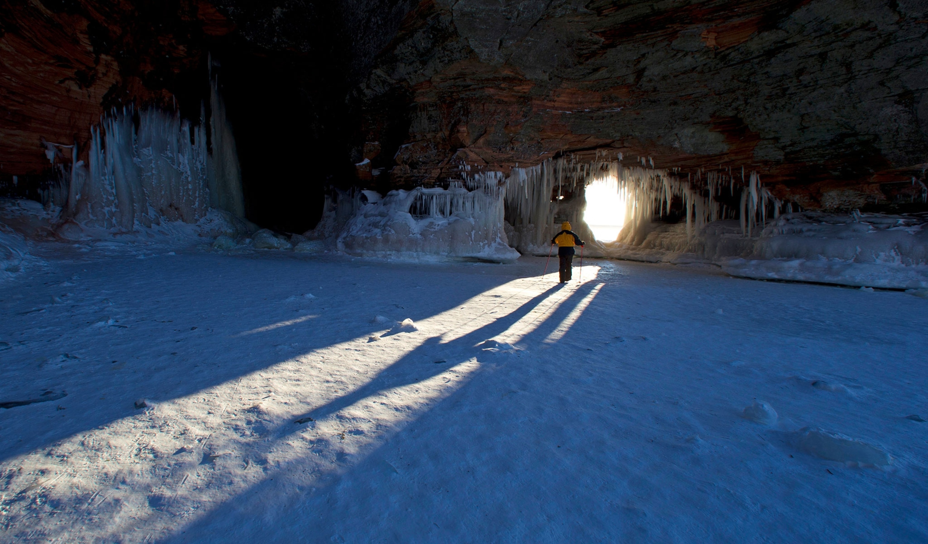 a hiker in an ice cave on Apostle Island National Lakeshore in Bayfield, Wisconsin