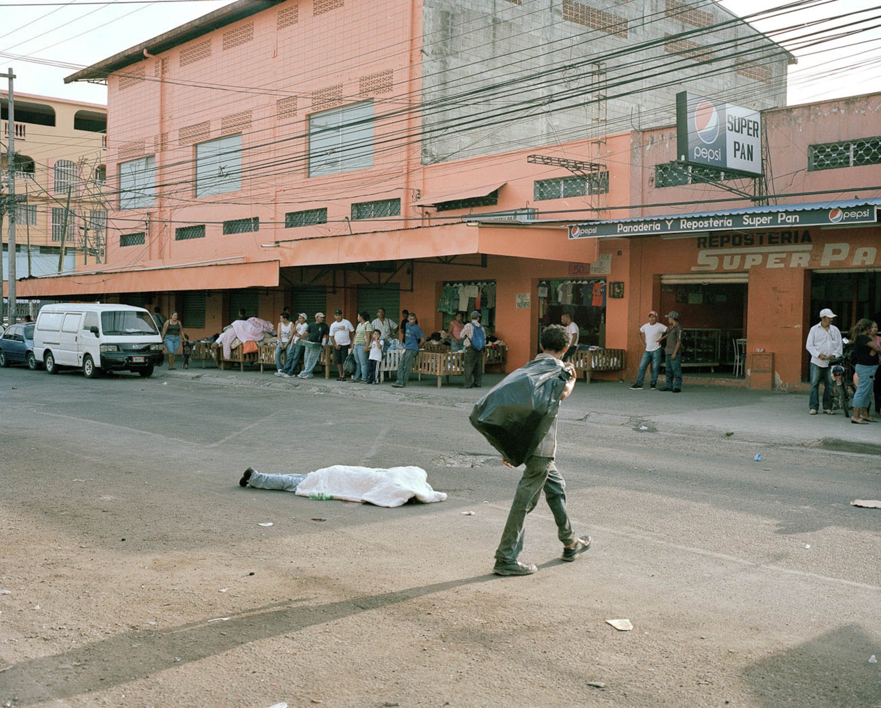 man walking across street by body