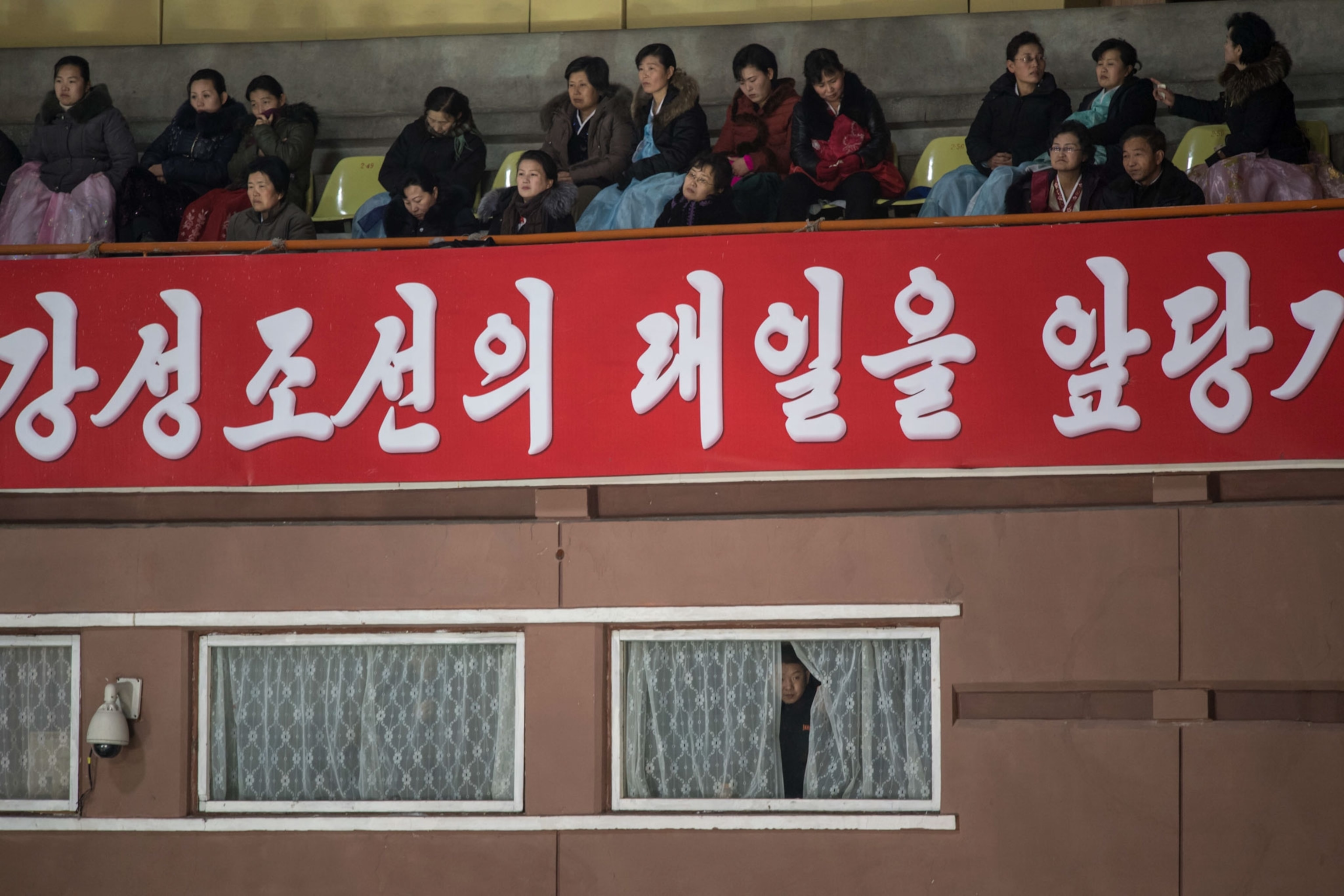 a person peering out of a curtain in North Korea