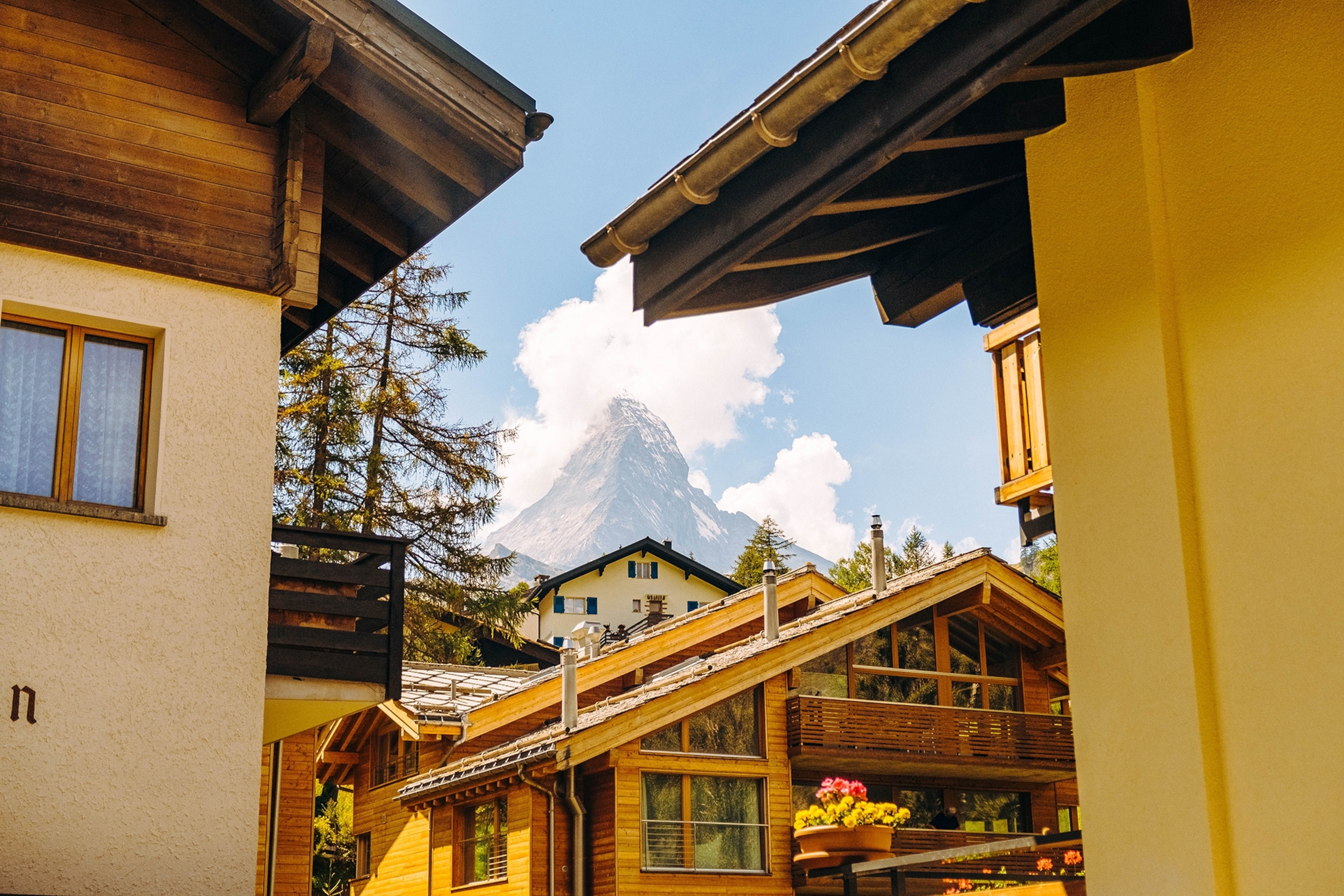A mountain peak shot through two Alpine houses.