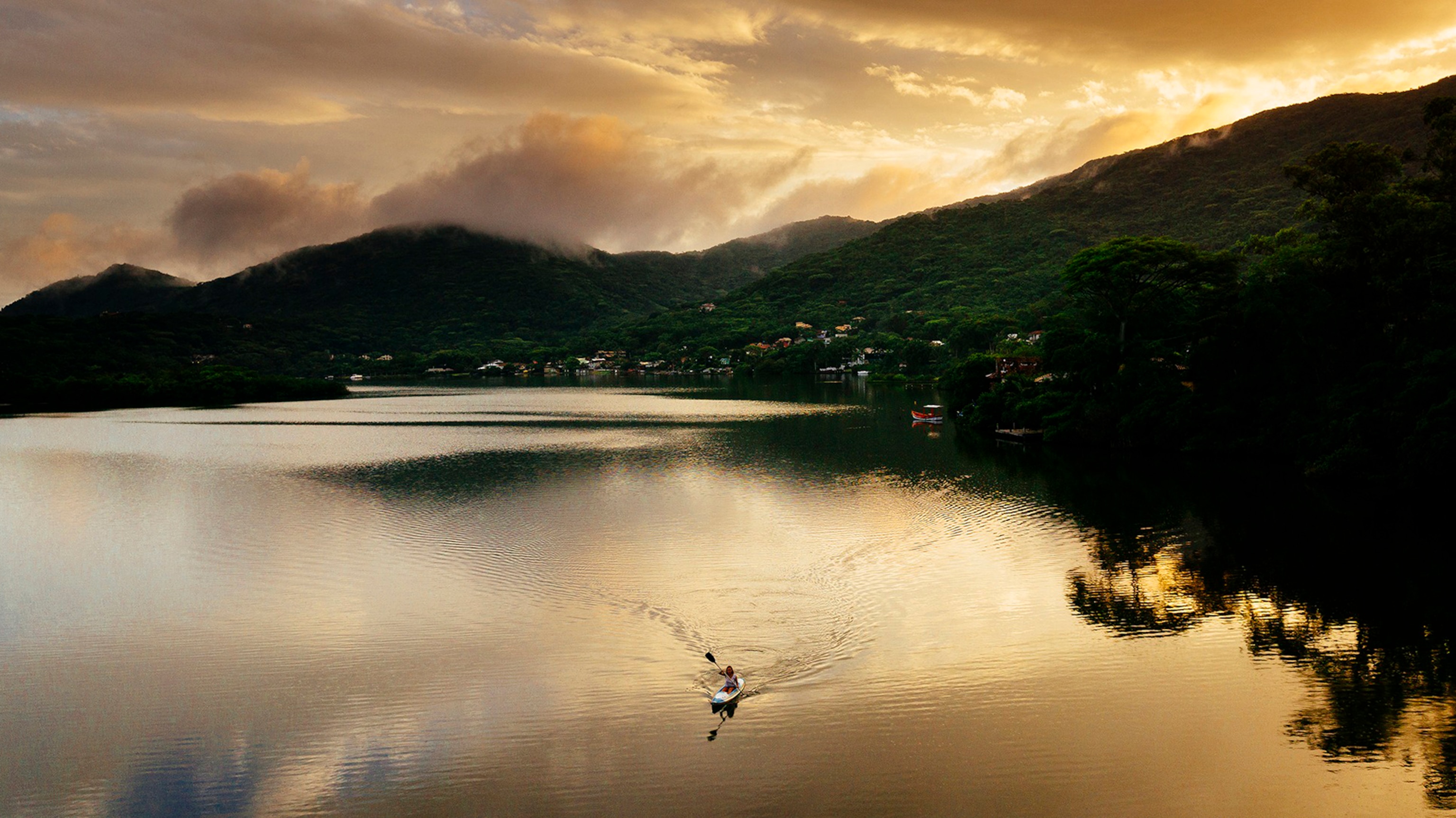 woman kayaking in Lagoa da Conceição, Florianopolis, Brazil.