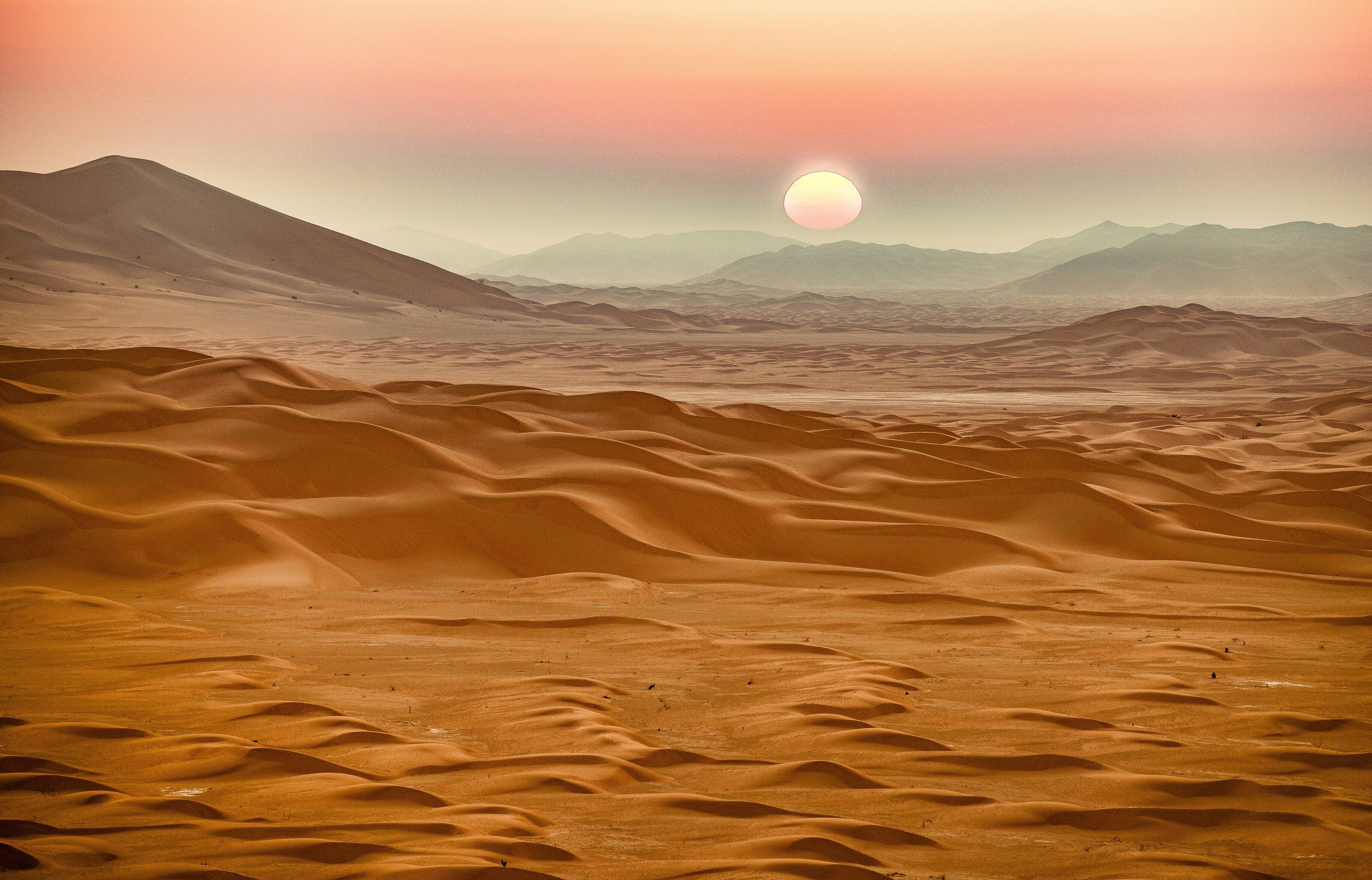 As the sun rises over the desert in the Rub' al Khali (Empty Quarter), myriad colours wash over the sand. The desert has been given this name because of its barren and inhospitable nature, and is heralded as the largest uninterrupted desert in the world, bordering Yemen, Saudi Arabia and the UAE.