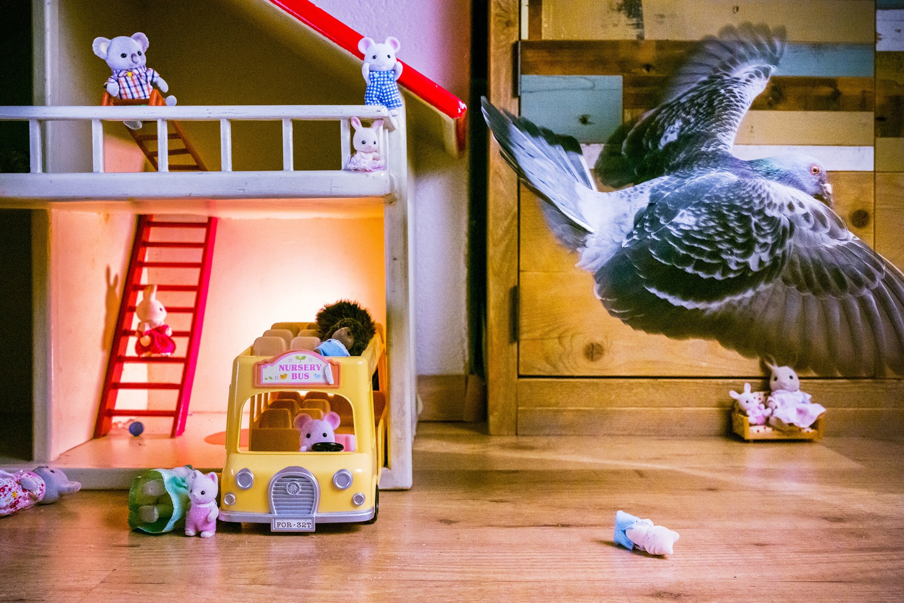 a pigeon flying away from a lit up doll house