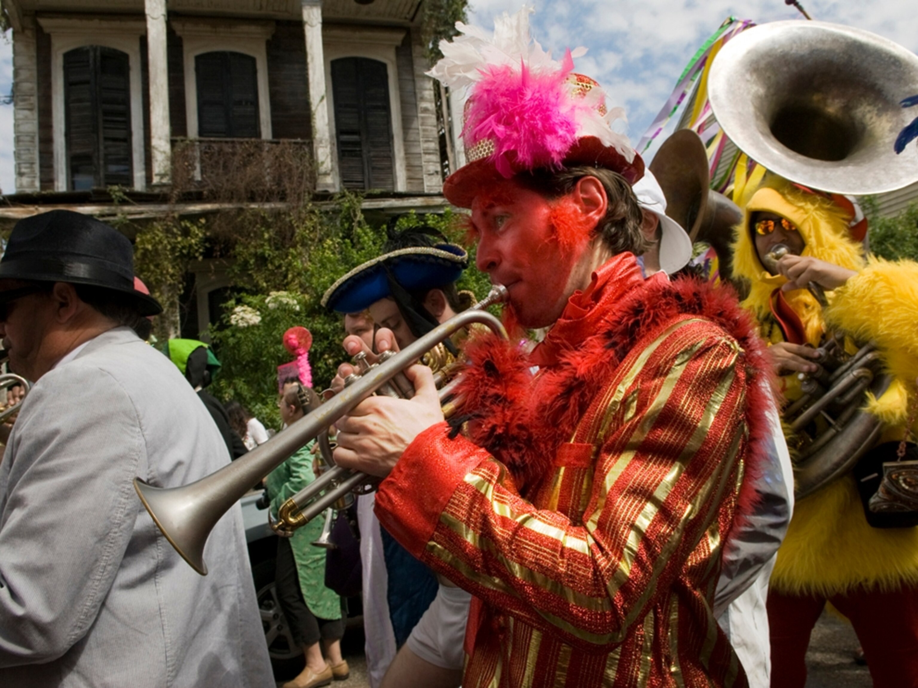 Man dressed as devil plays trumpet in parade