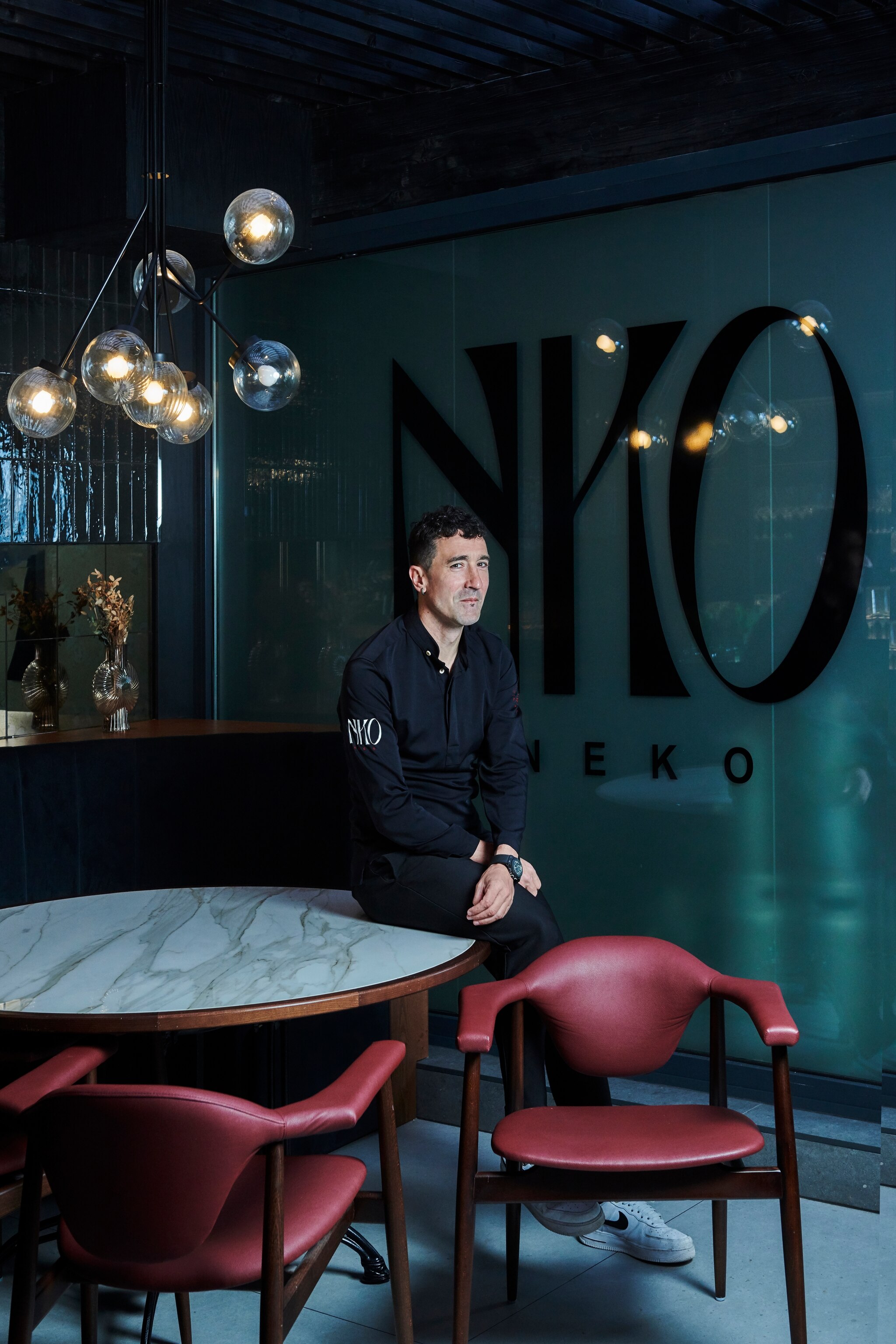 Eneko Atxa sits on a table in his NKO restaurant.
