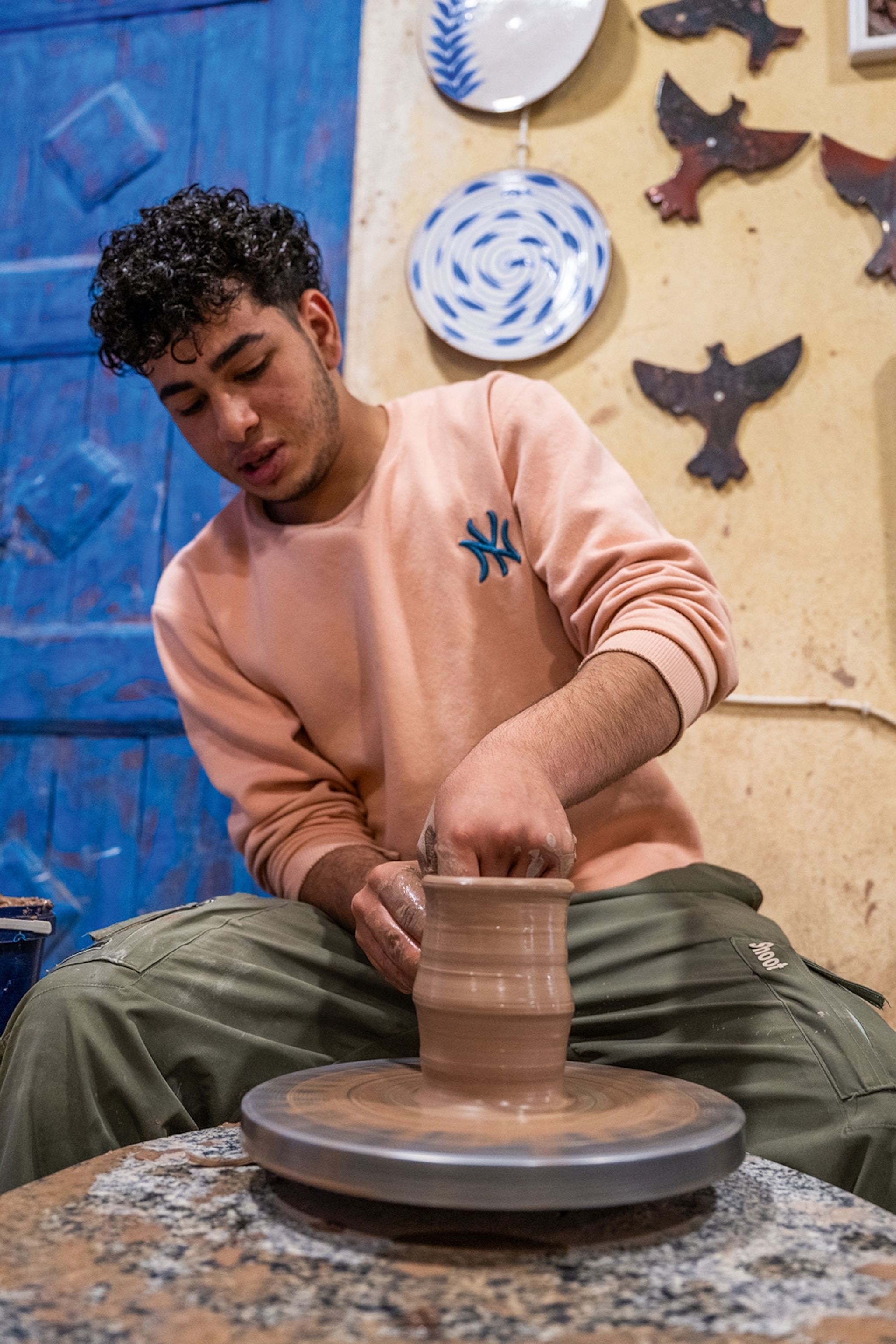 A young potter at the wheel in his studio.