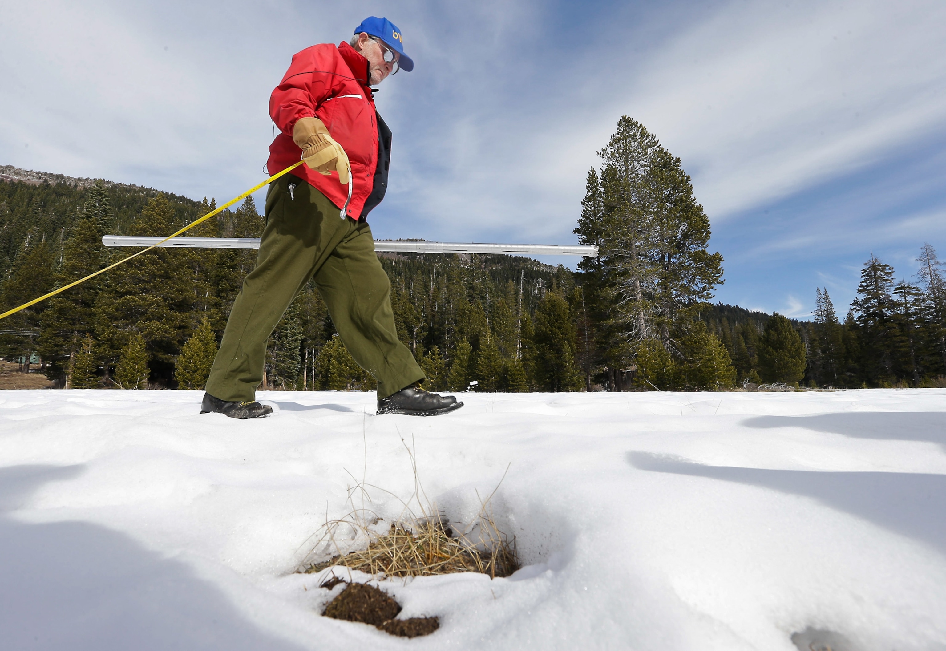 a man walking over the snow in California's Echo Summit conducting snow survey
