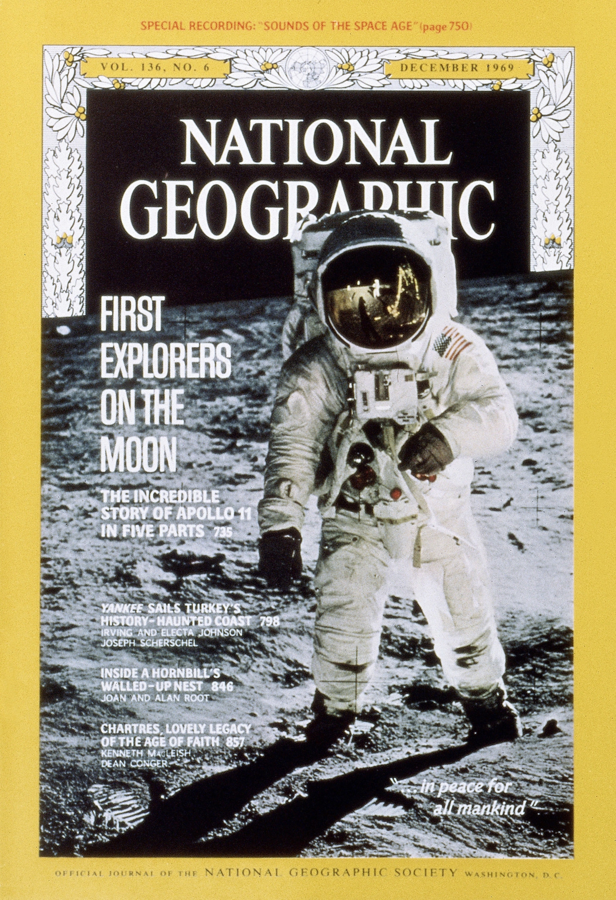 Wearing a bulky space suit, lunanaut Buzz Aldrin walks on the moon. His visor reflects Neil Armstrong and Eagle at Tranquility Base.