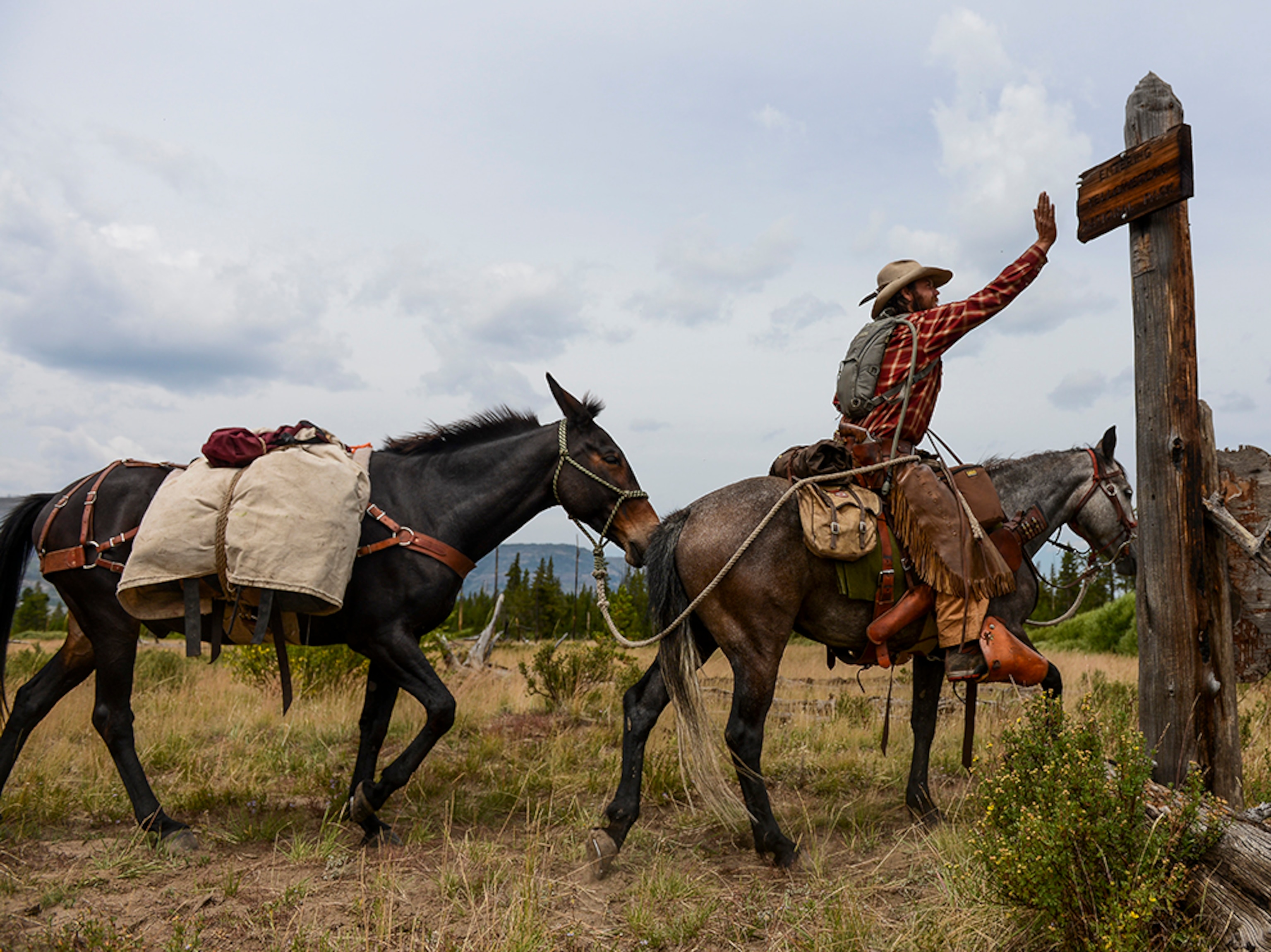 Army Special Forces veteran Ray Knell slapping a sign marking the end of his journey.