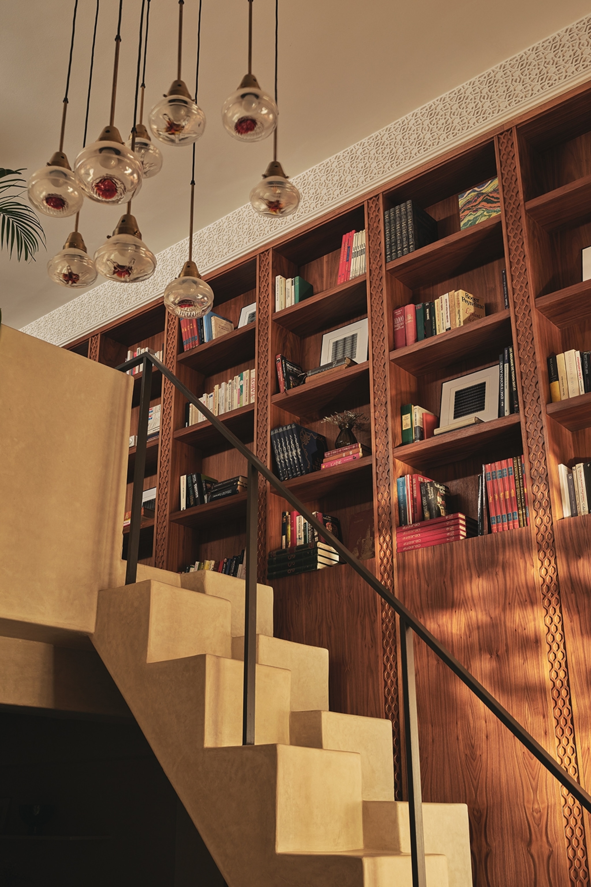A stone staircase in a mezzanine-style hotel room with a wall of books on the side.