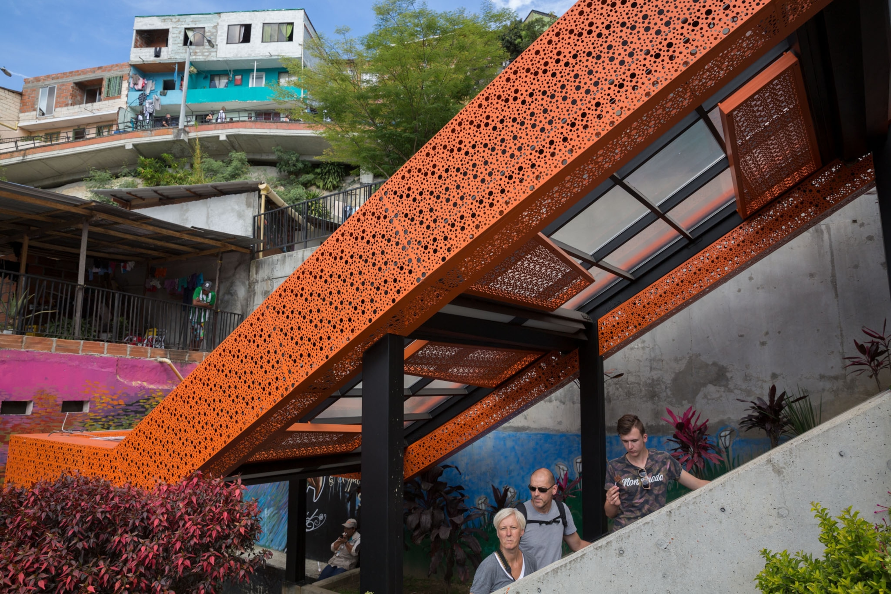 an orange roof escalator with three tourist looking out to take in the view