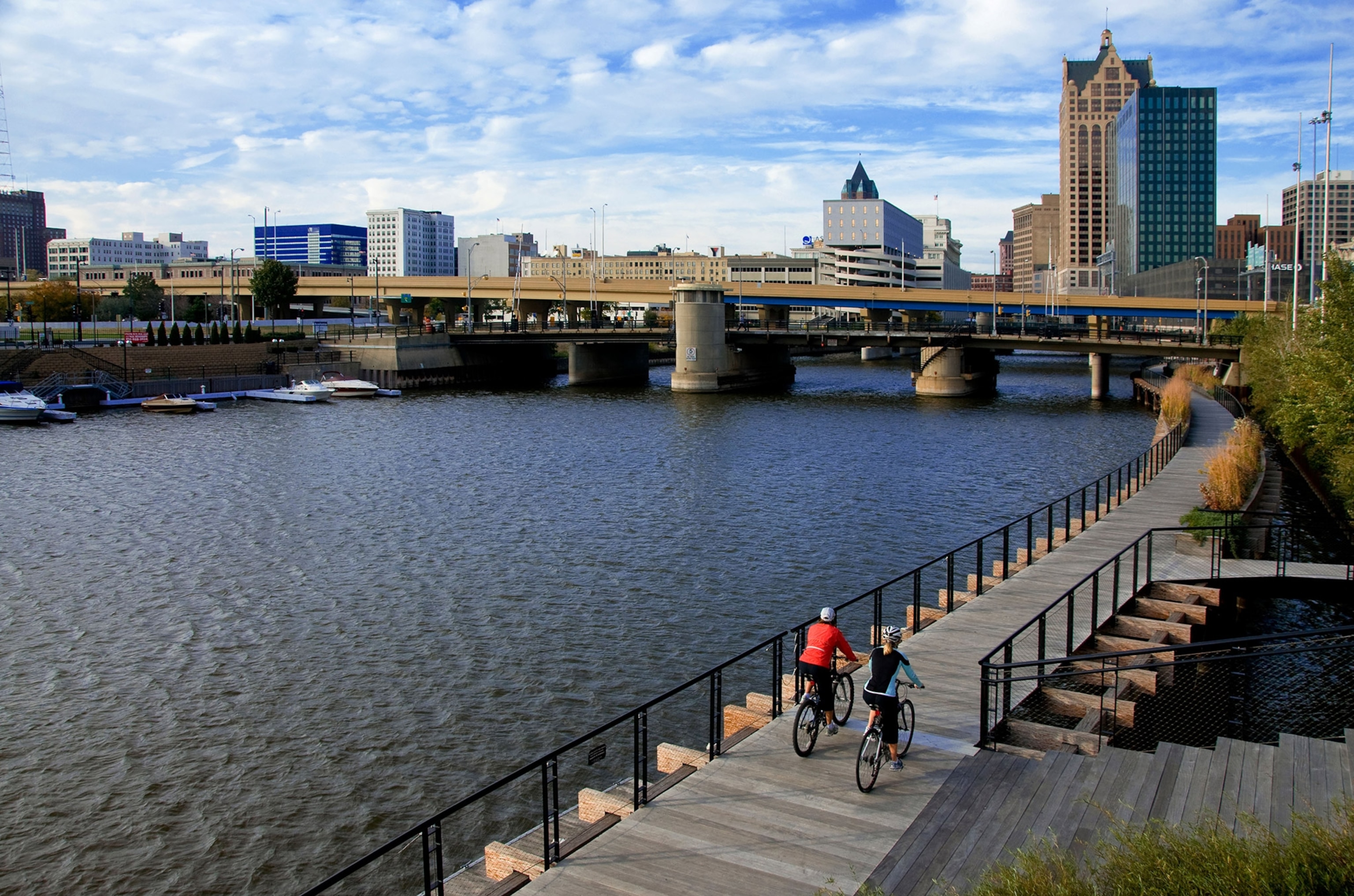 a couple cycling along the Riverwalk in downtown Milwaukee Wisconsin
