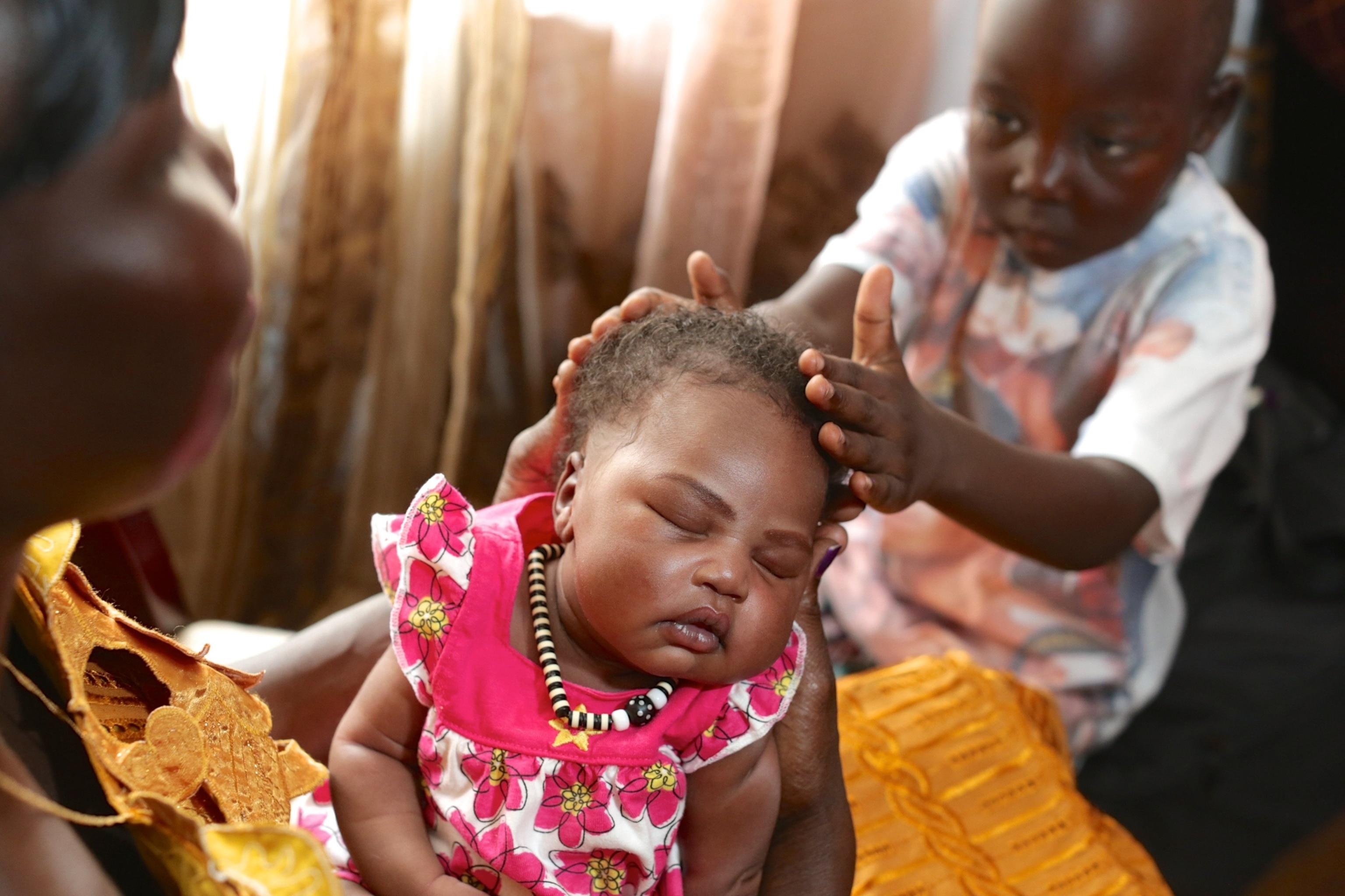 a child touching a newborn