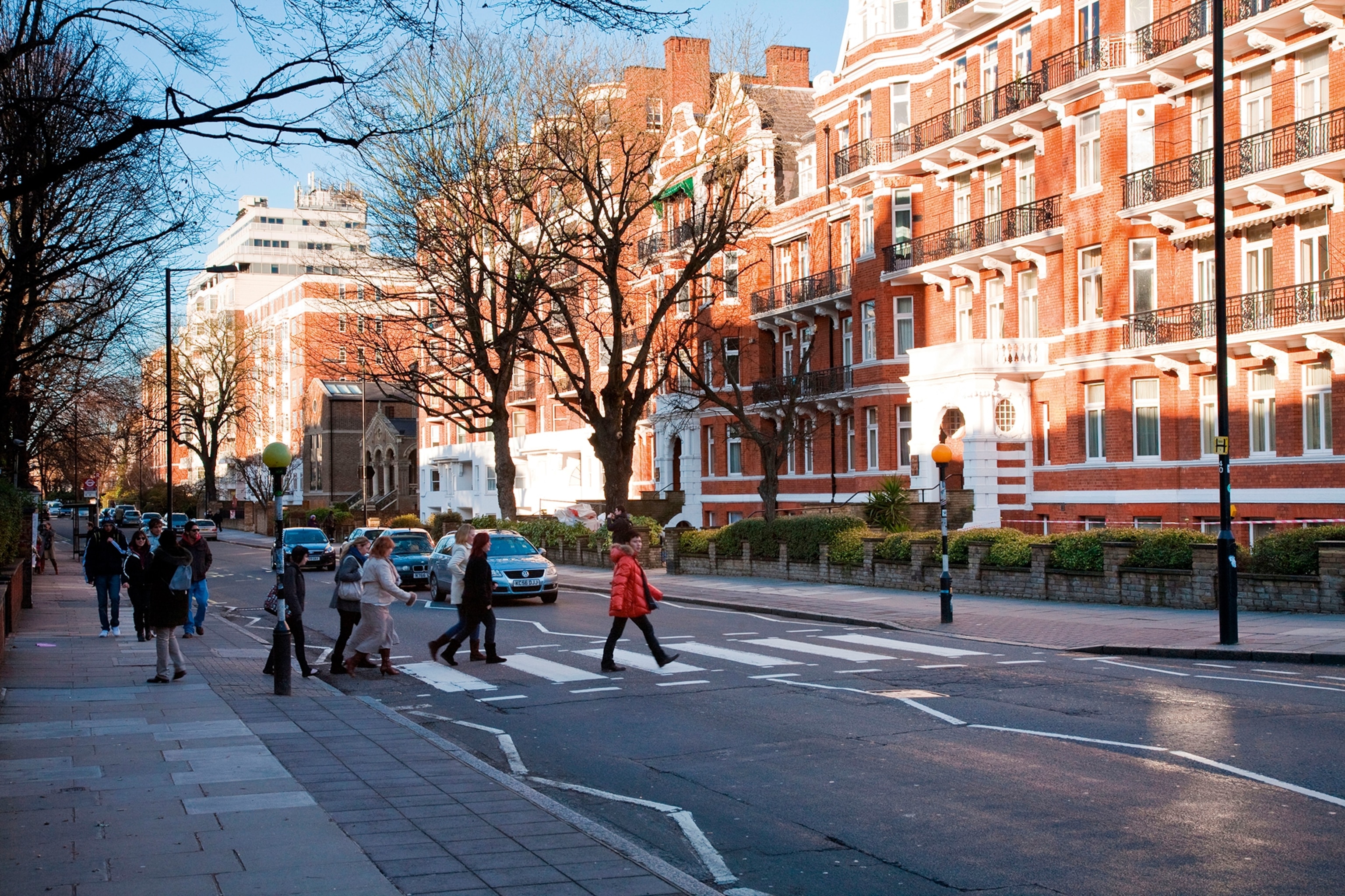 A group of tourists attempting to cross a zebra crossing on a street in North London.