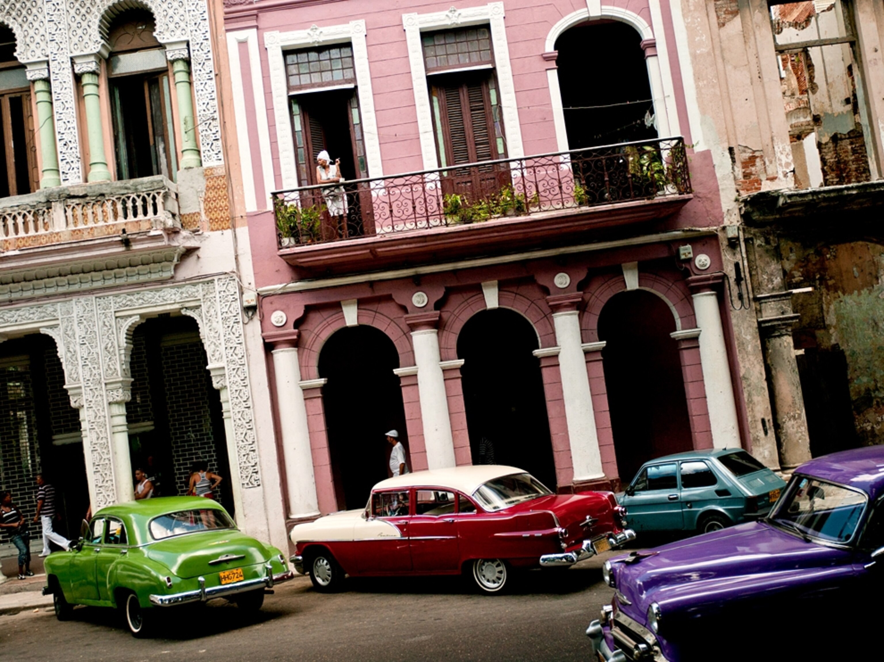 A street scene near older buildings and cars in Old Havana, Cuba