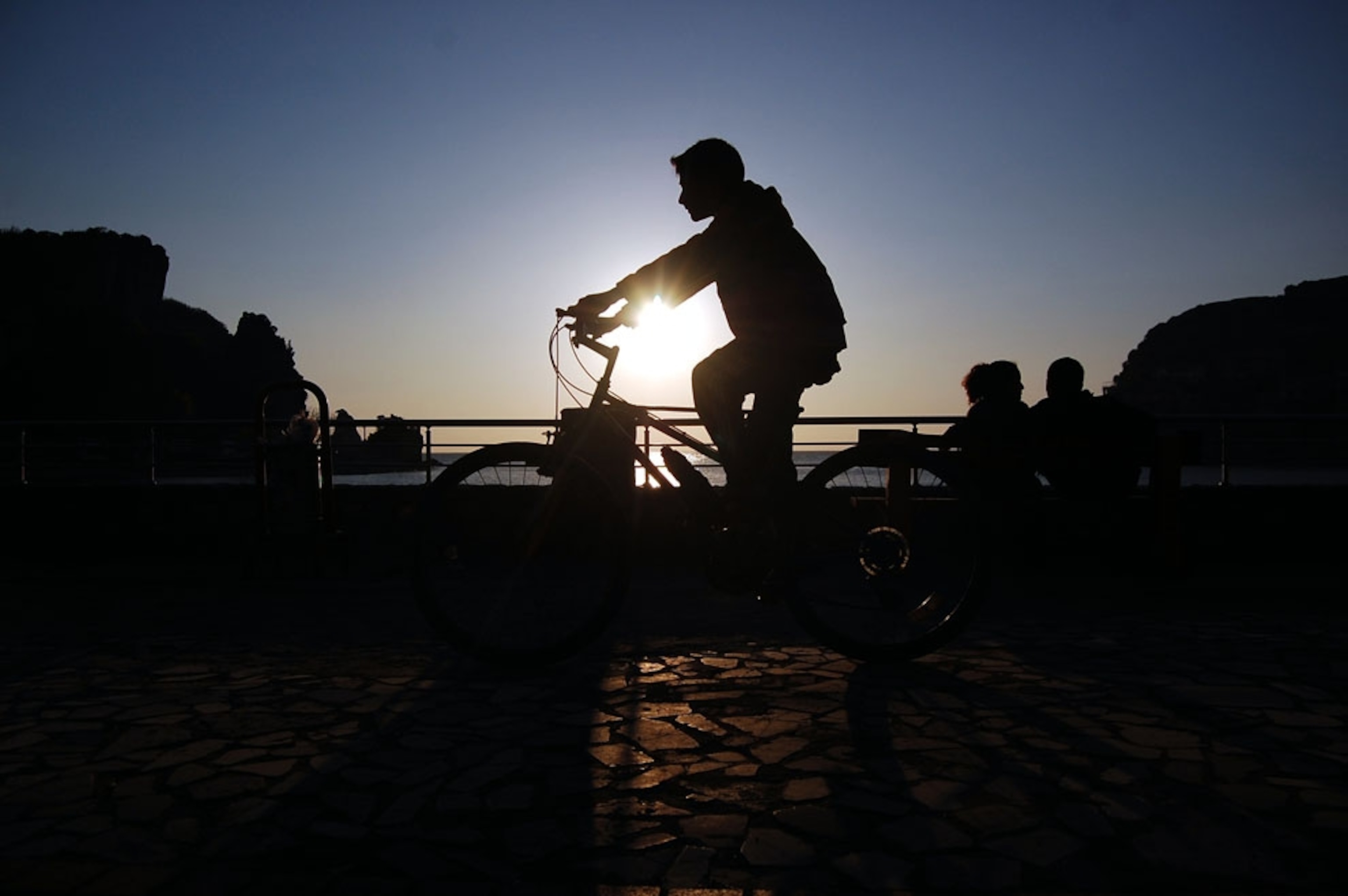 A boy rides a bike at sunset in Turkey