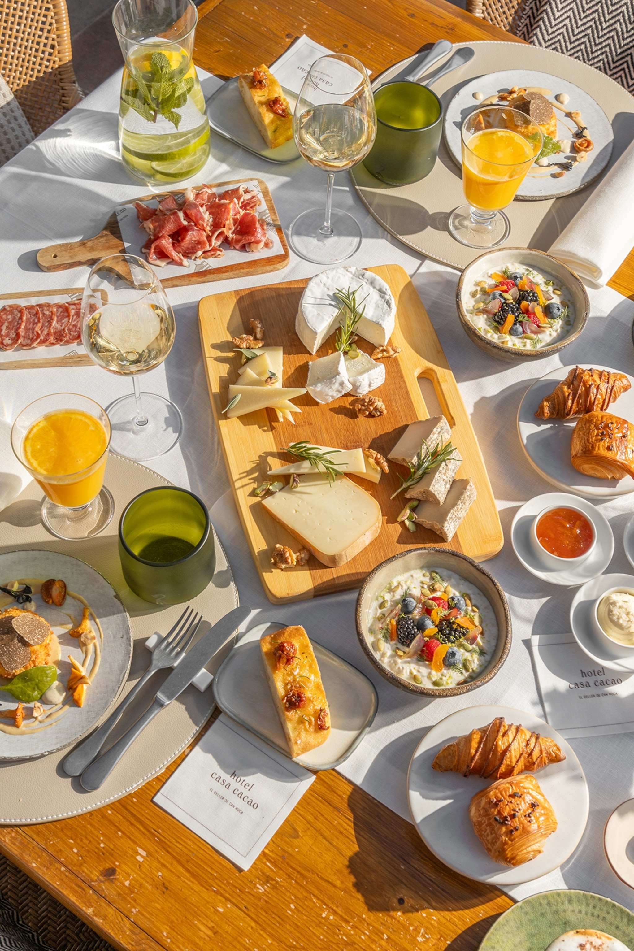 A lavish breakfast spread including cheeses, bread, spreads and juices.