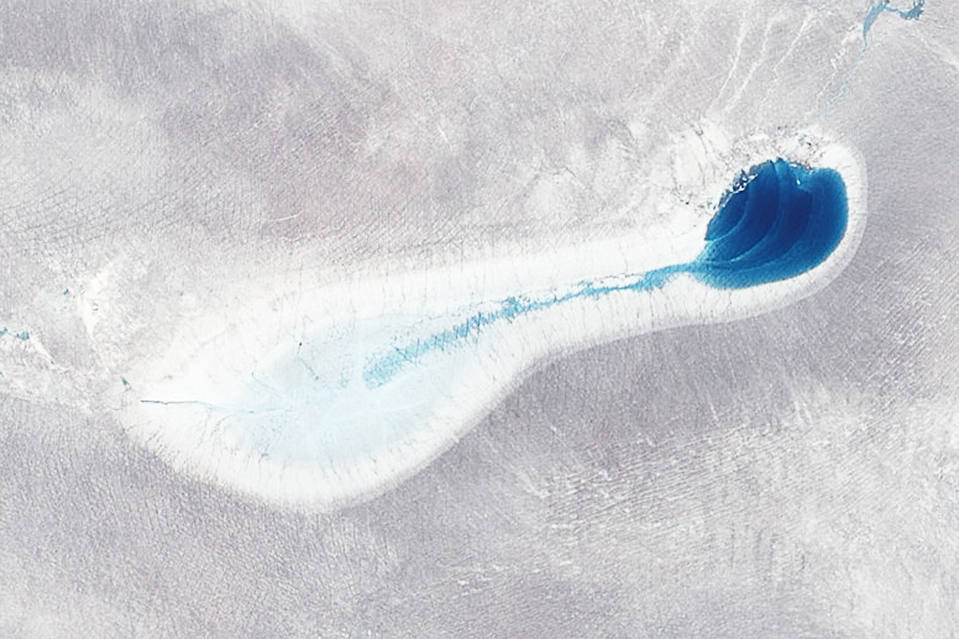 a blue pool of meltwater from a Greenland ice sheet