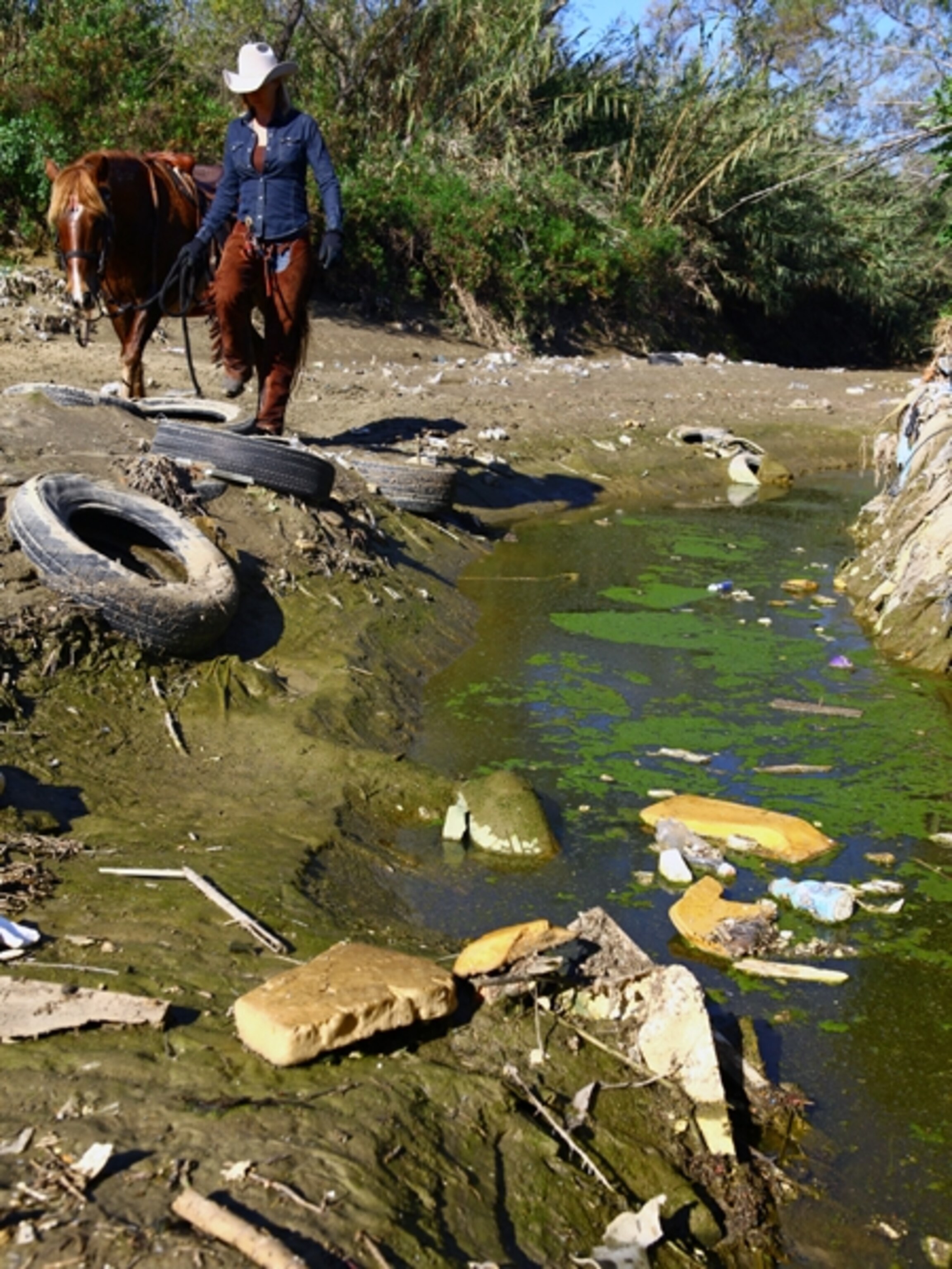 Trash chokes a tributary of the Tijuana River after a storm, the trash flows from the heart of Tijuana south of the US/Mexico border, crosses back to the US side and empties out at Imperial Beach.