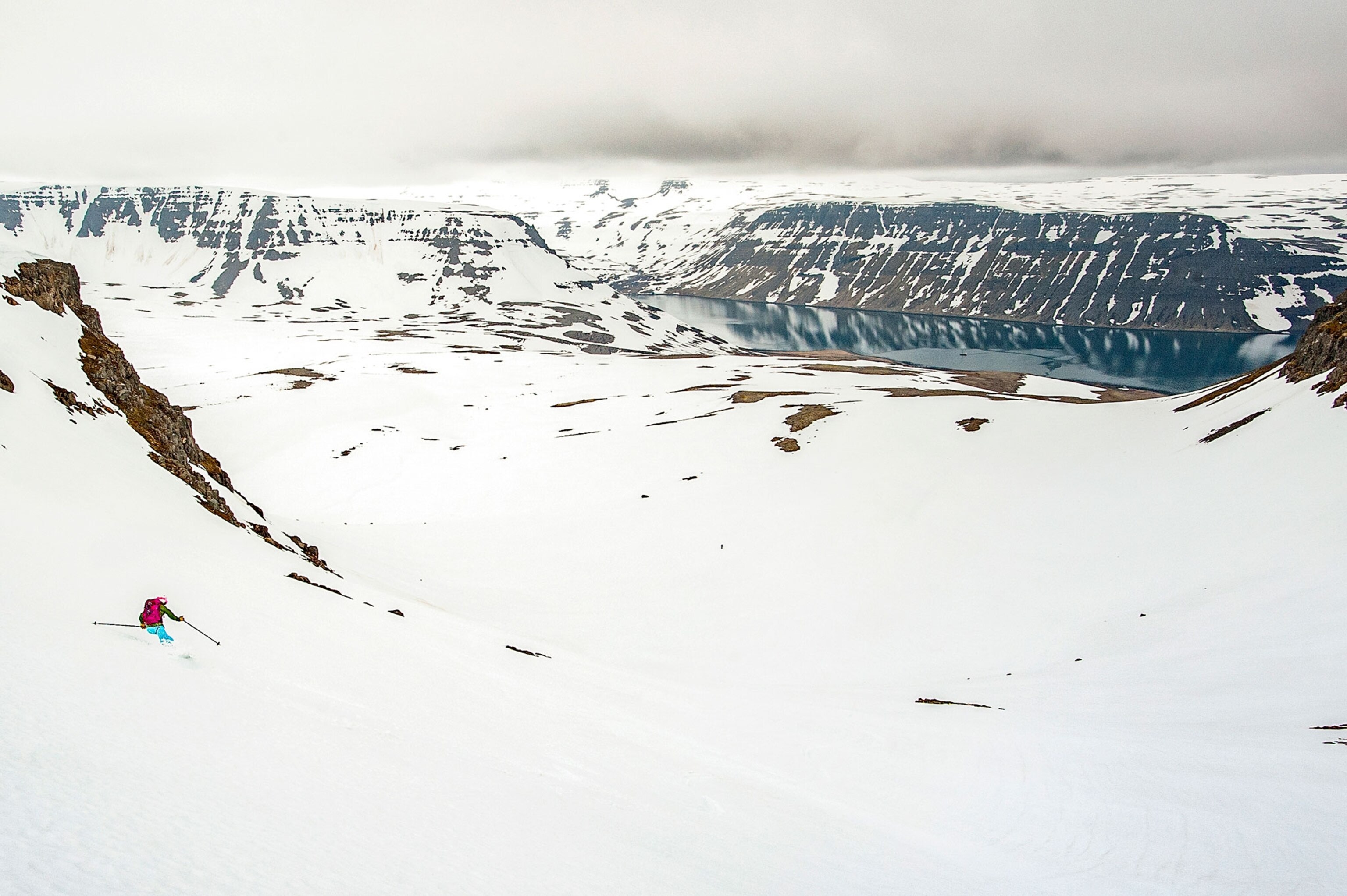 skier skiing down to a fjord in Iceland