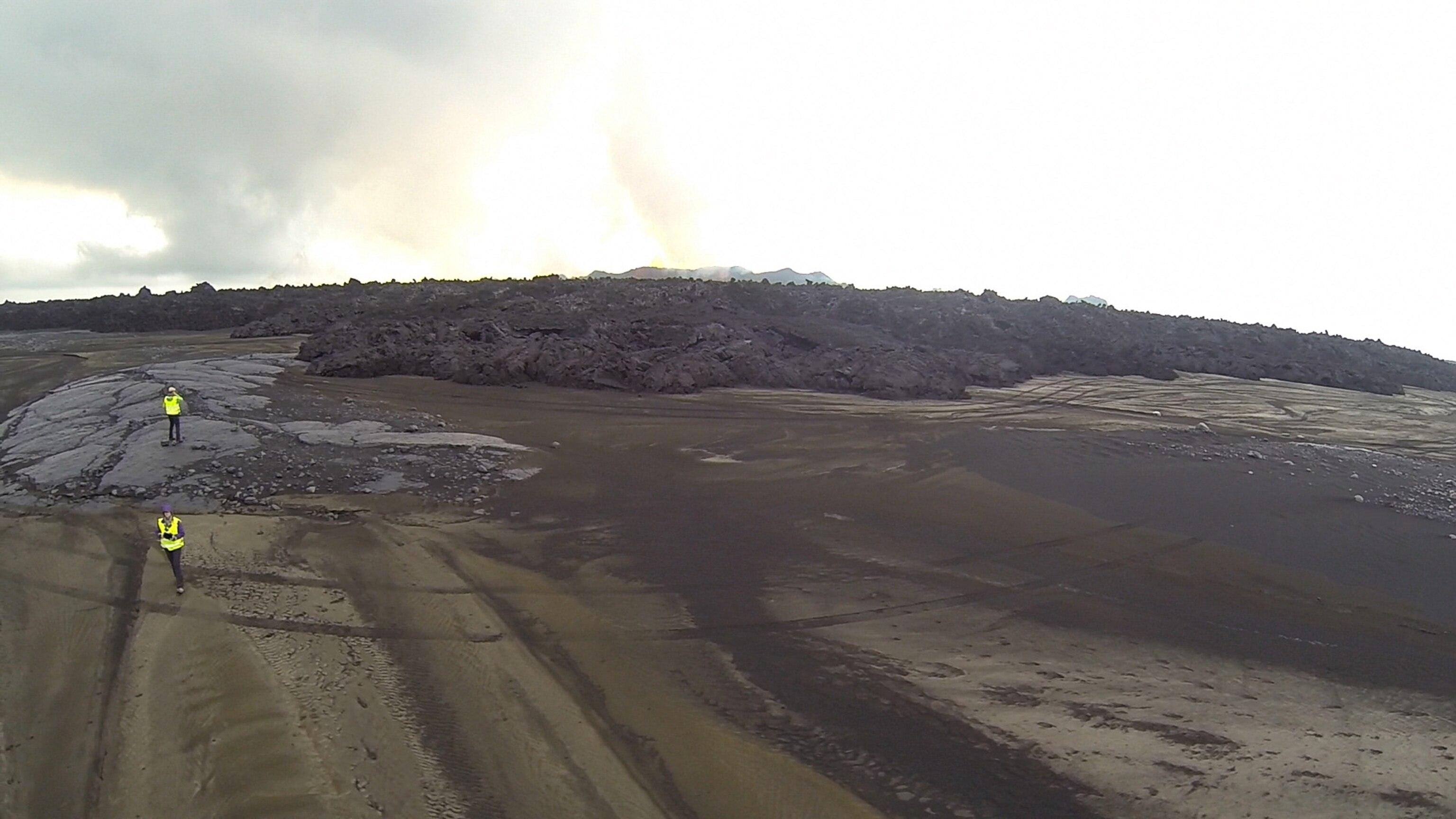 Gabriella and Anton as seen from above in a black and rocky landscape