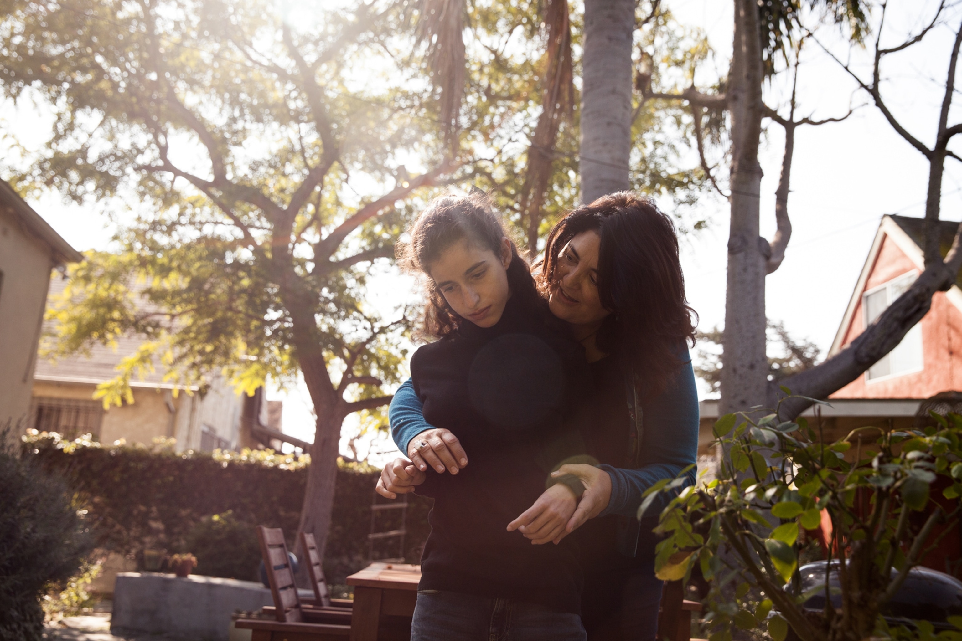 Elizabeth Aquino embracing her daughter Sophie Beglinger in their backyard