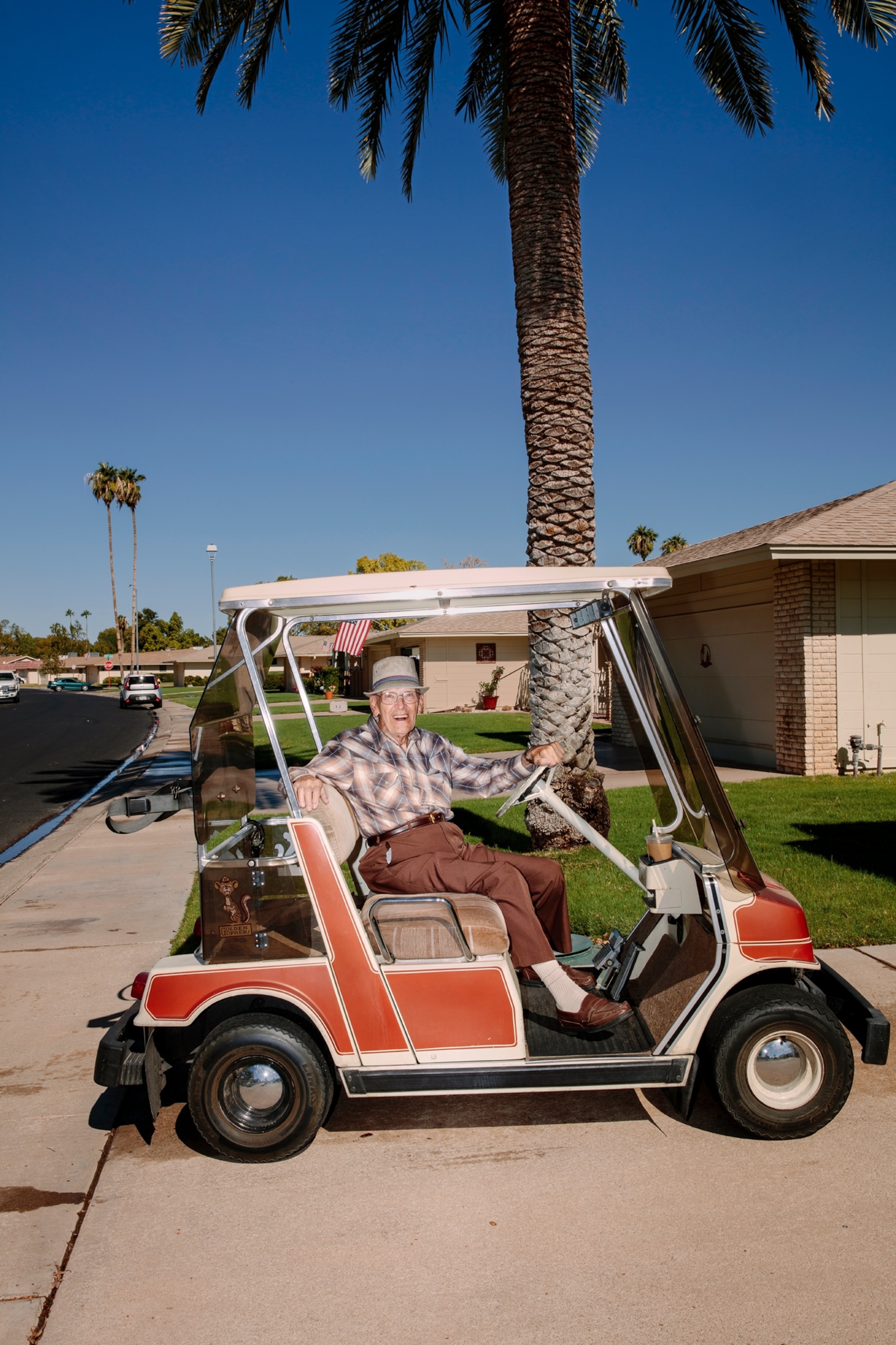 Picture of old man smiling from the golf cart.