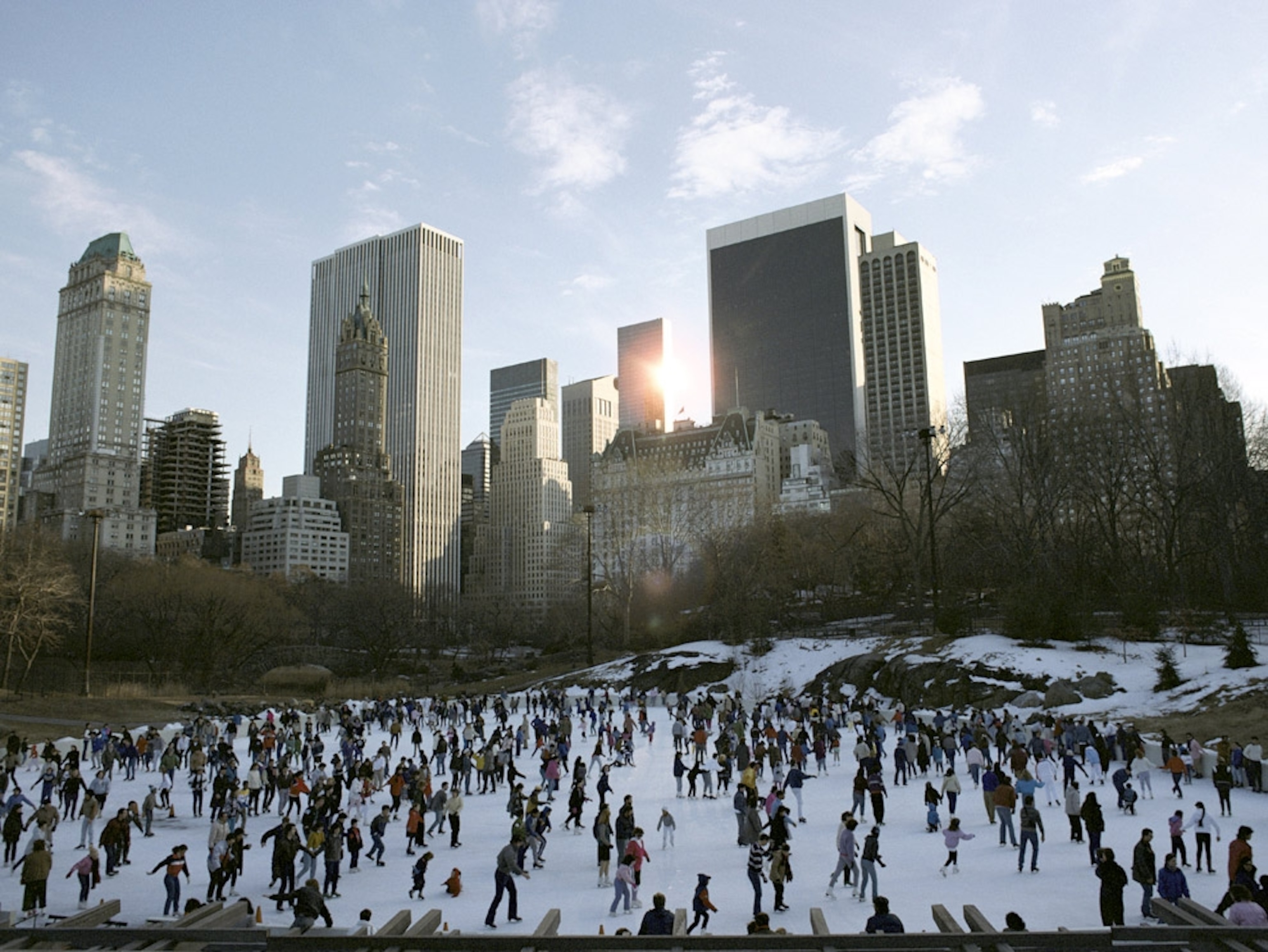 Ice skaters in Central Park amid the cityscape of New York