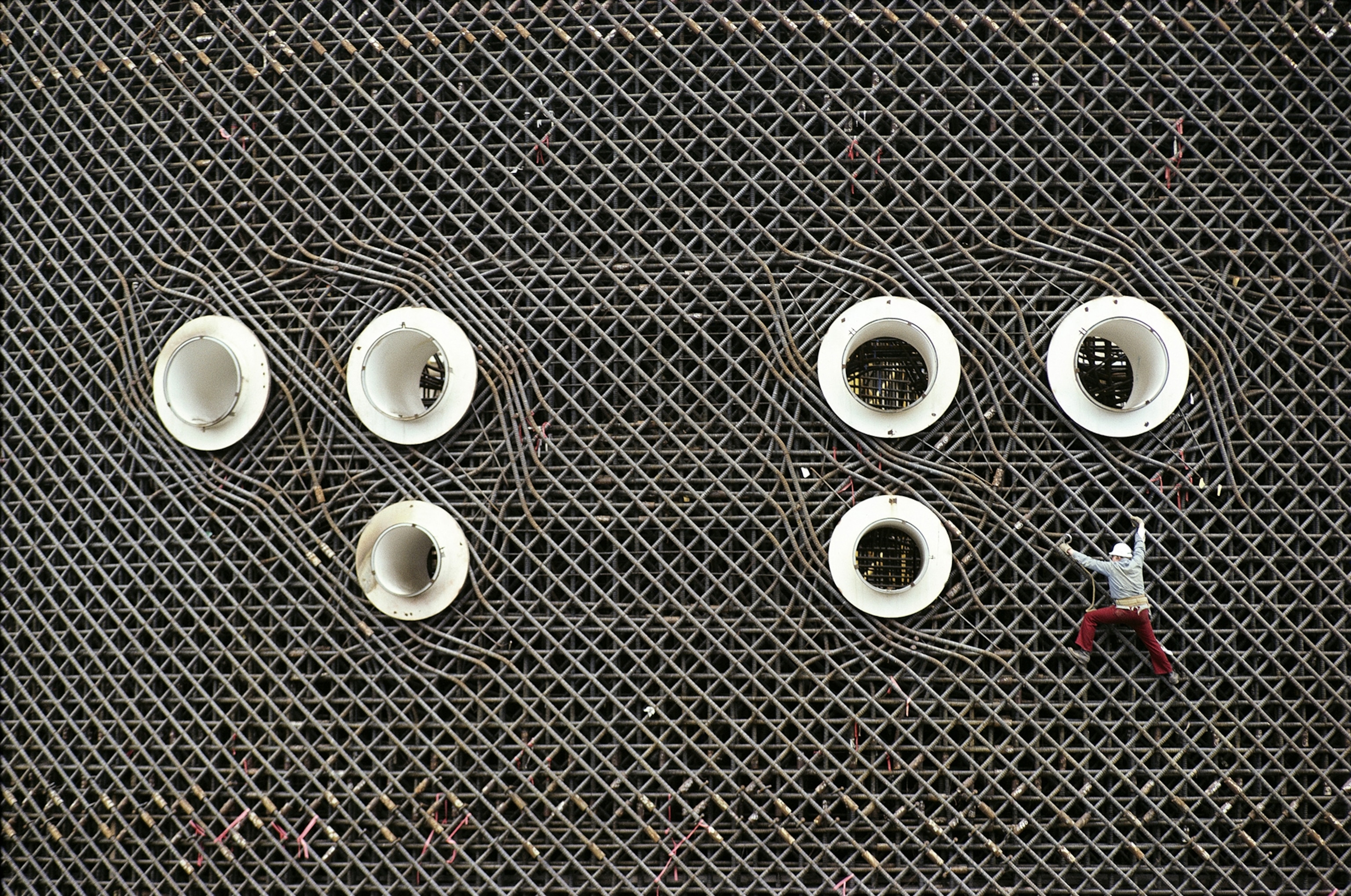 A worker scales a lattice of steel rods during construction of the Hanford Nuclear Plant in Richland, Washington, in 1980.