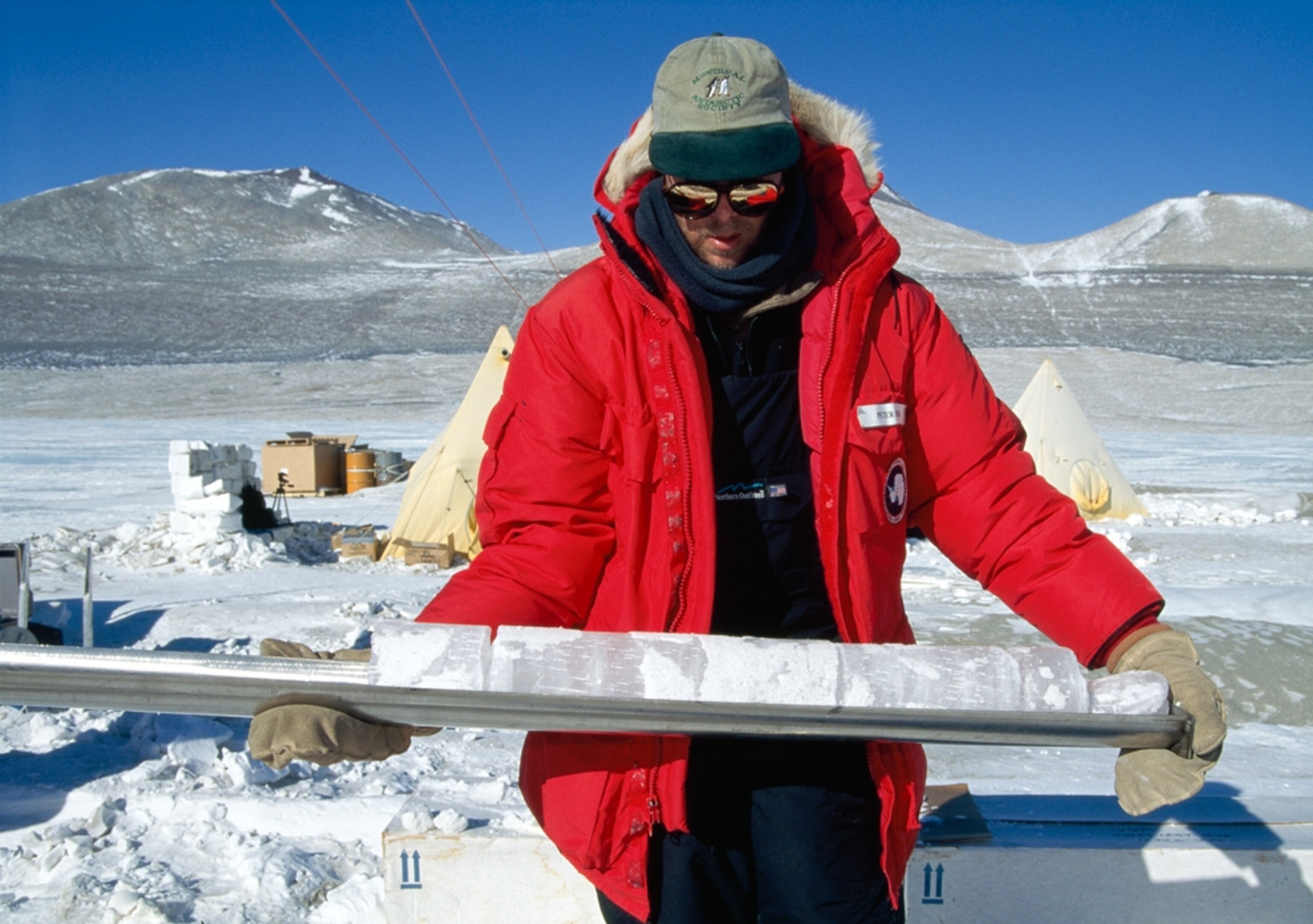 a person holding a three-inch-thick piece of ice from Lake Vida