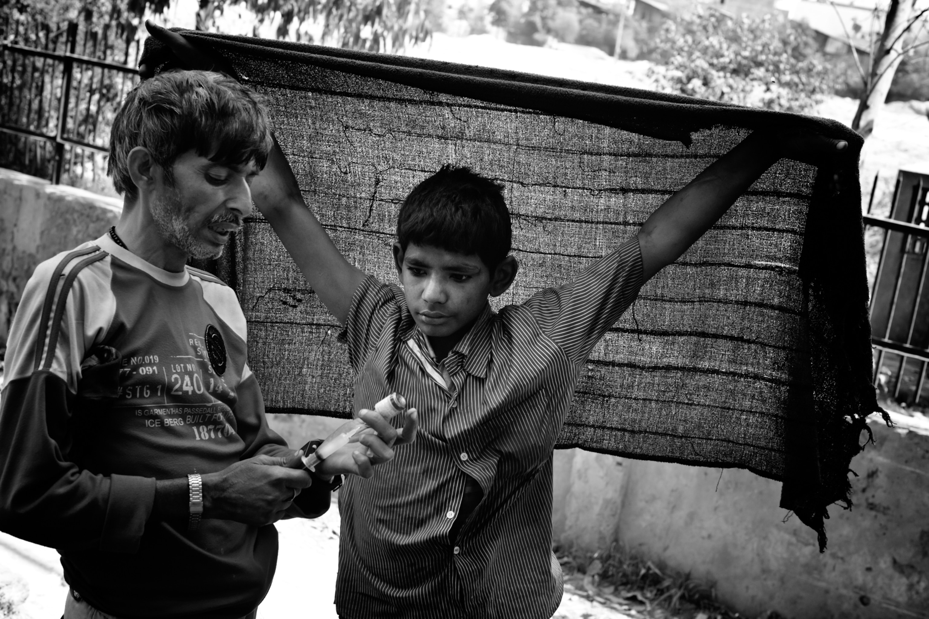 Mohammed, a 15-year-old addict, watches closely while an older addict prepares an injection. For young addicts the relationships to the older and more experienced users can mean safety and danger at the same time. Crime and violence among the users is quite common.