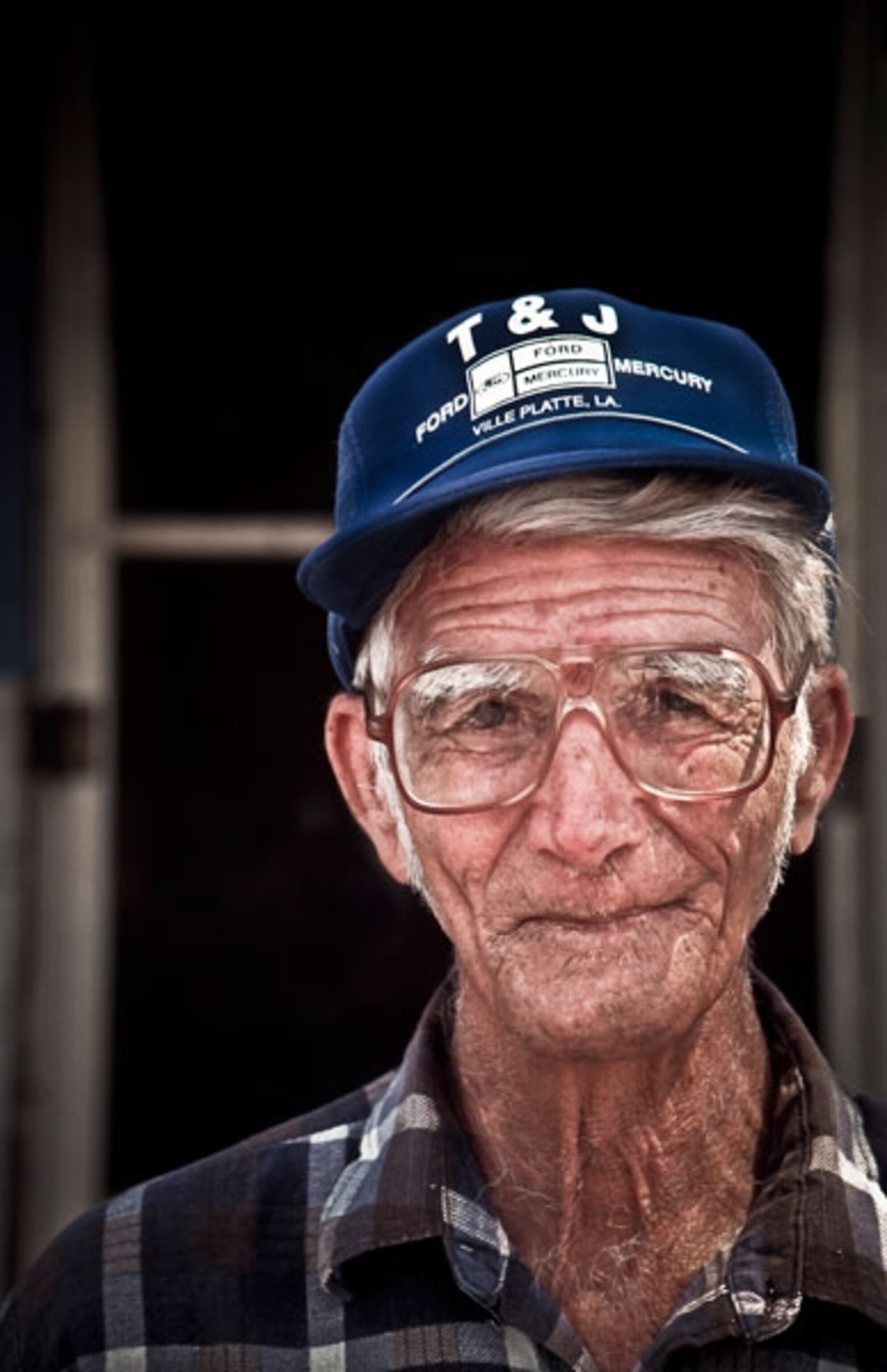 Tripani Moreau stands on the front porch of his home
