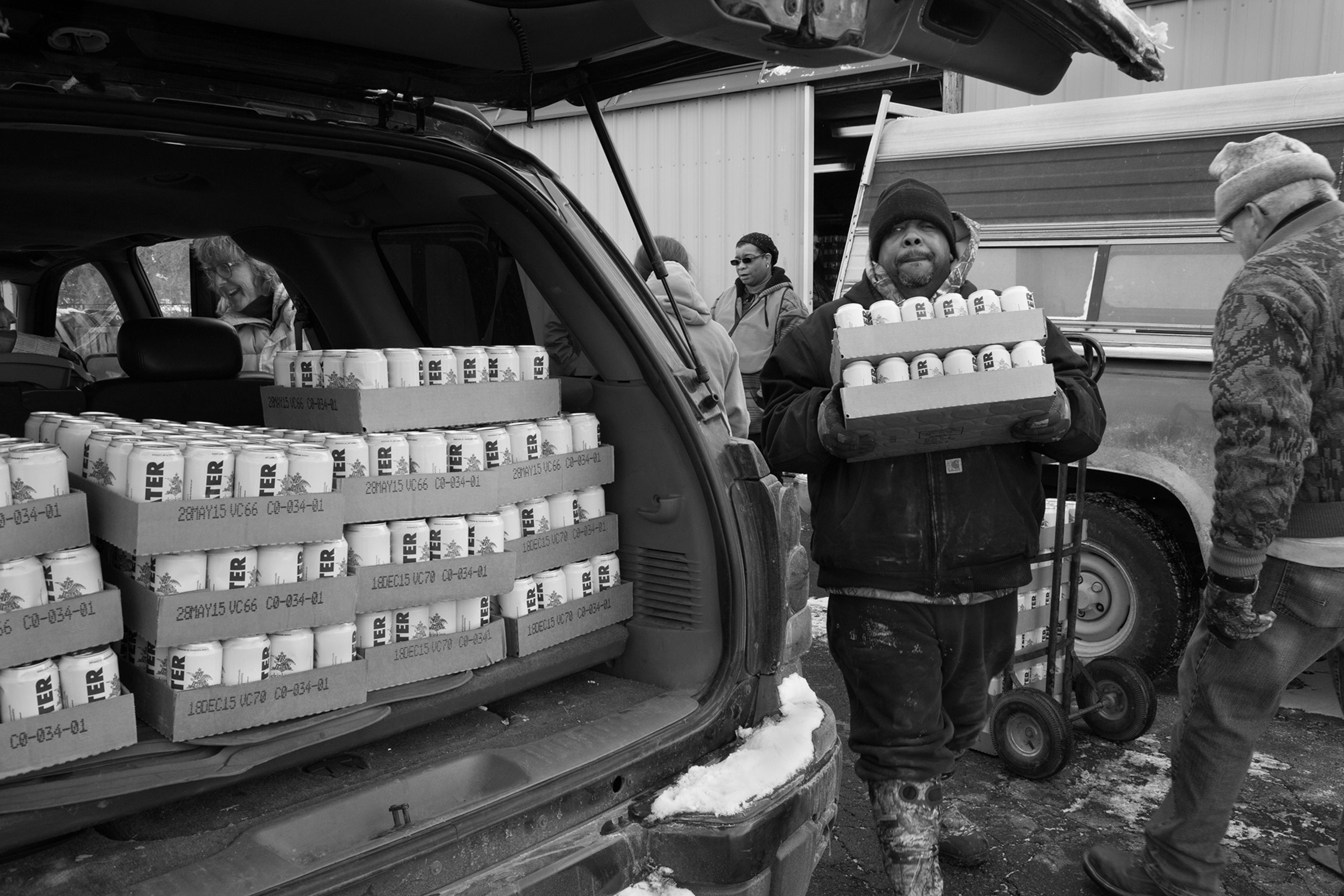 man carrying water to his car