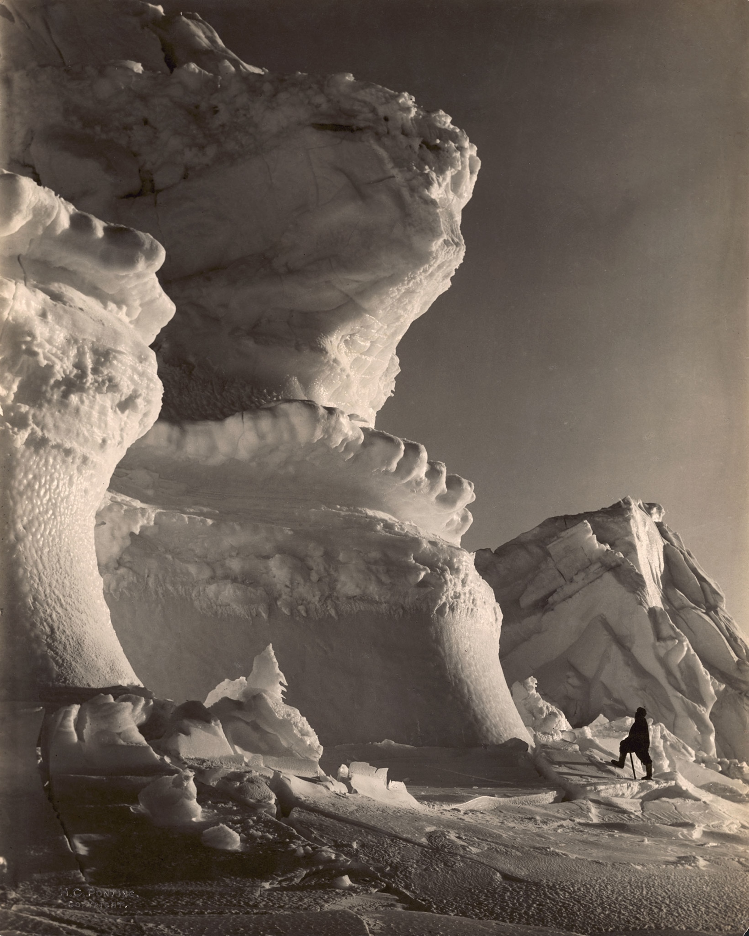 a person standing near an iceberg