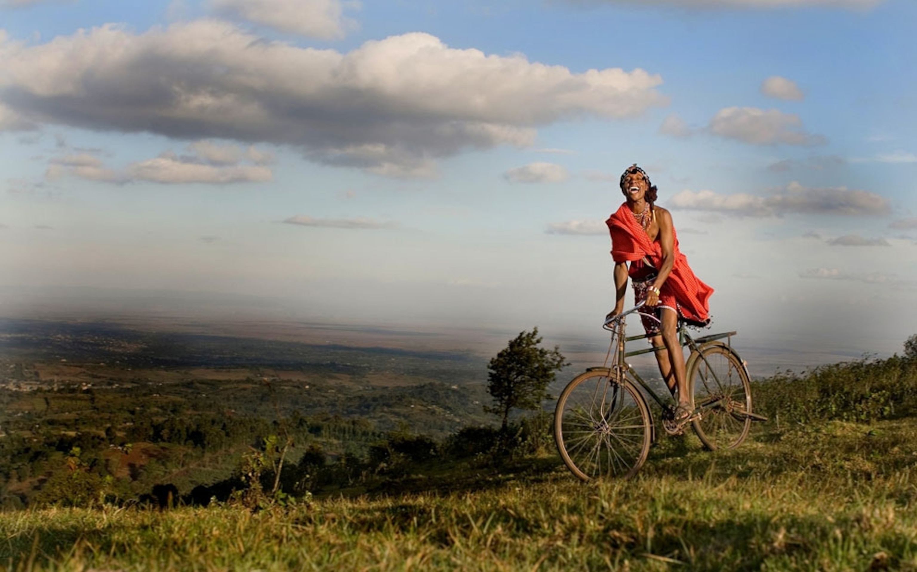A Maasai man rides a bike above the Ngong Hills, Kenya
