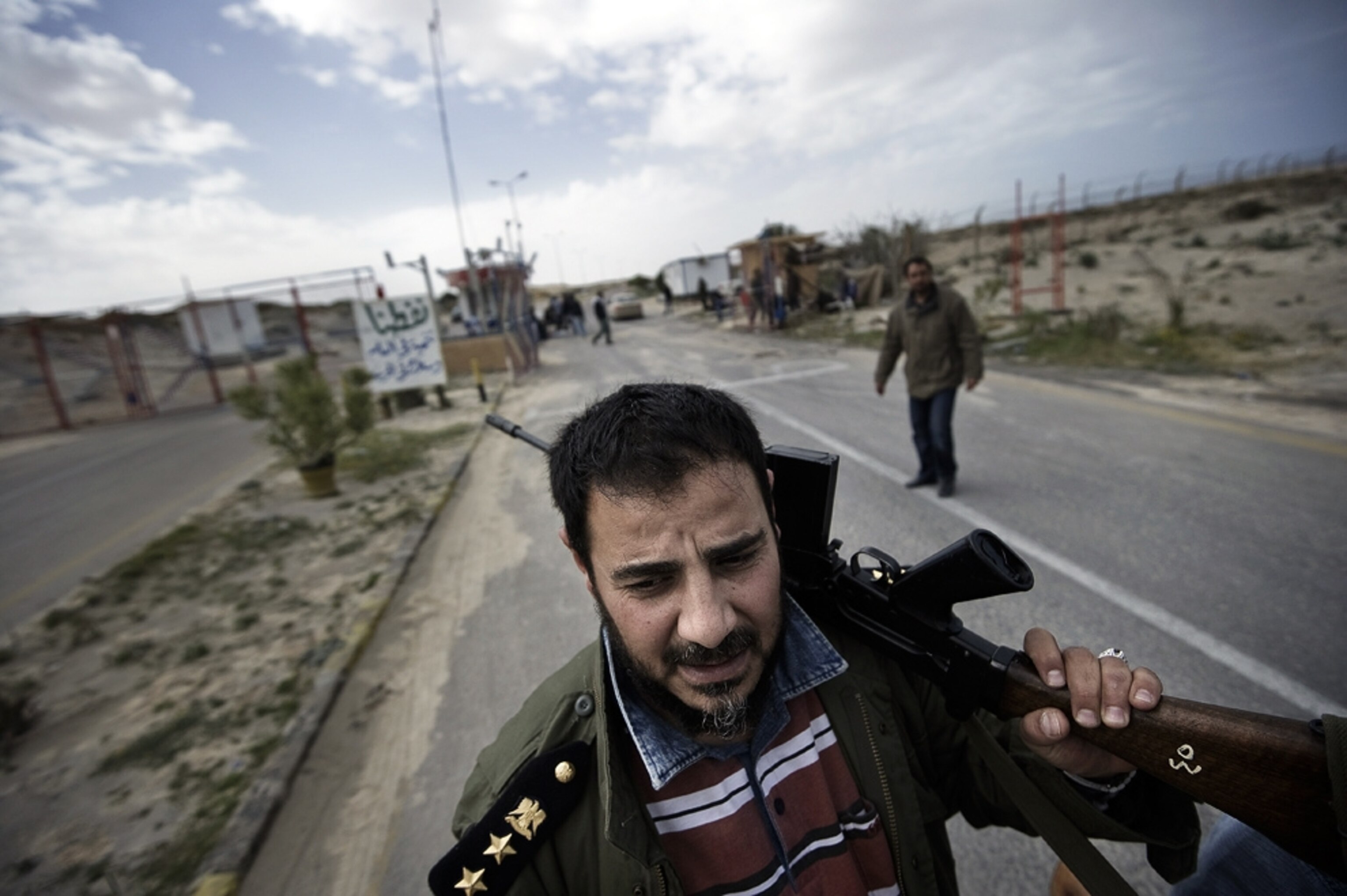 A Libyan rebel fighter patrols outside a refinery in Brega.