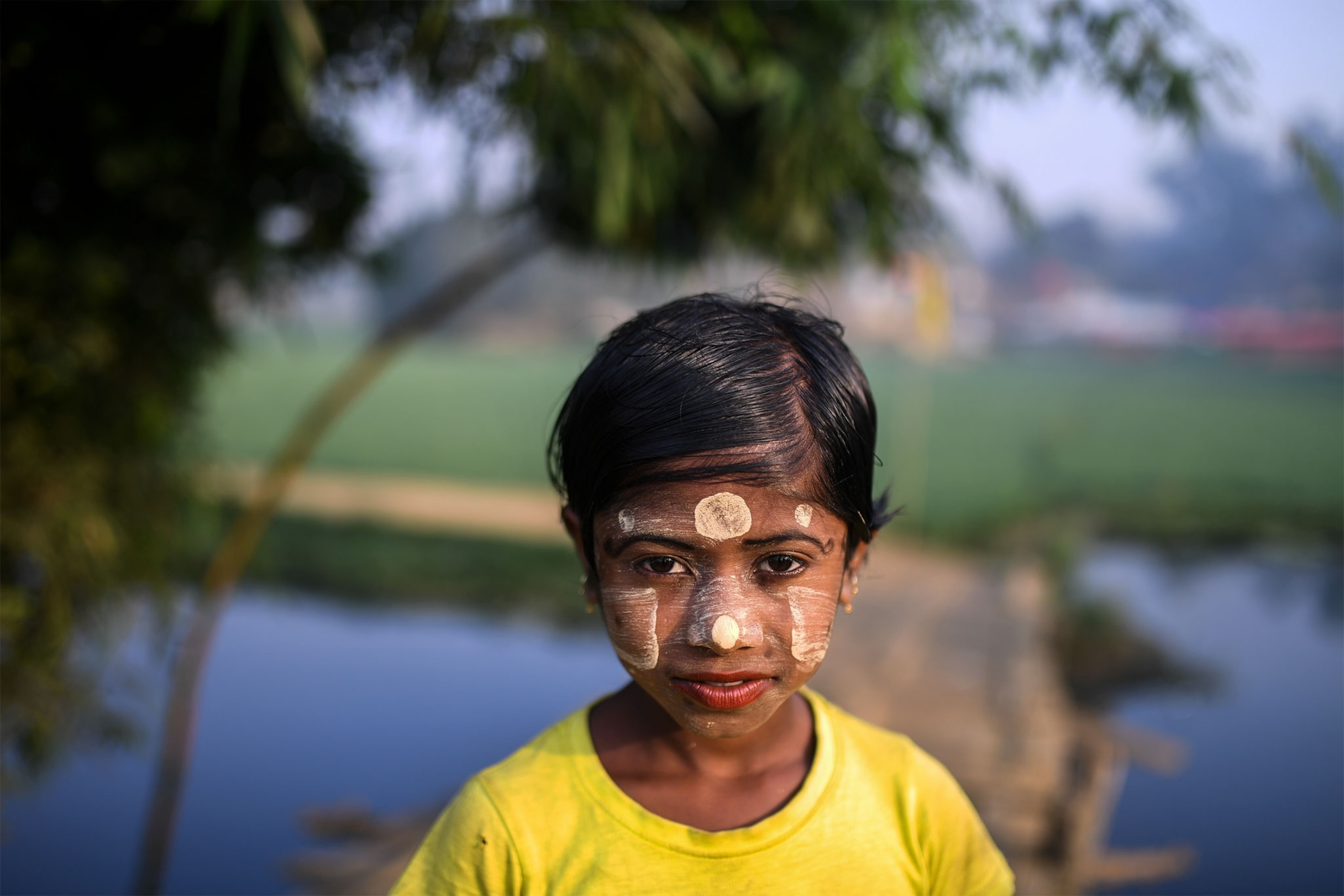 a Rohingya girl wearing paint on her face to protect her from the sun
