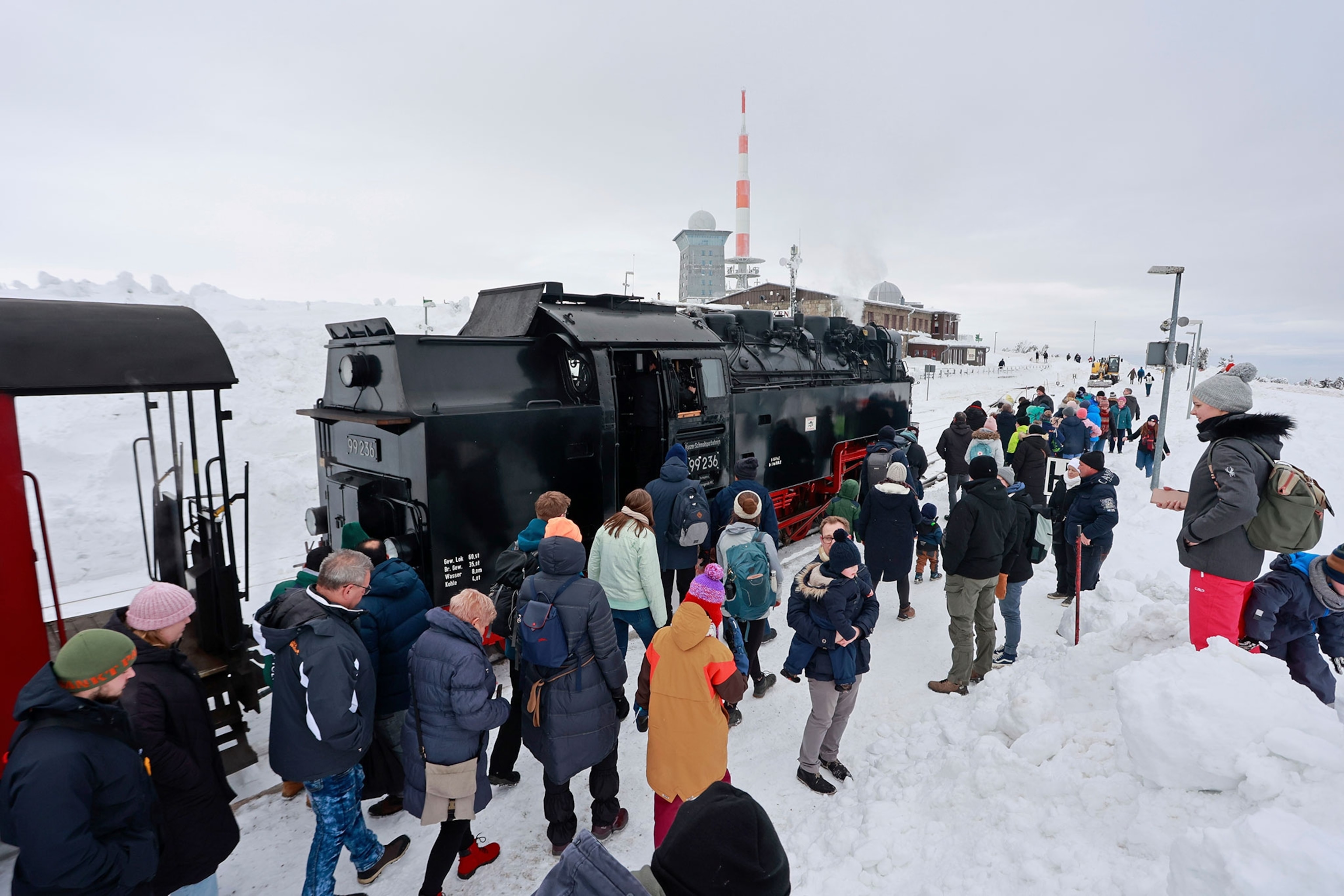 Visitors stand on the Brocken after a train of the Harzer Schmalspurbahnen GmbH has reached the Brocken summit.