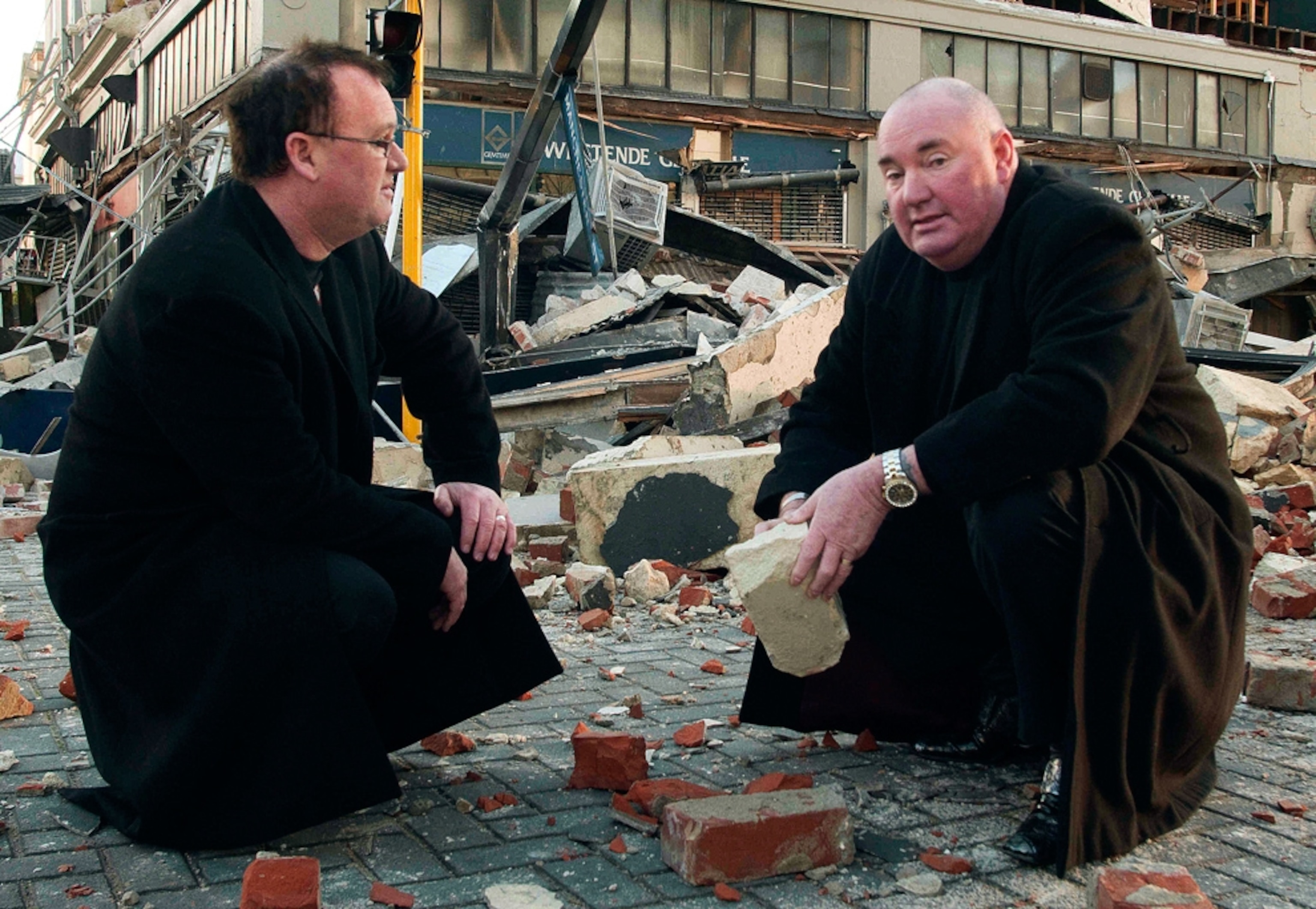 A picture of owners outside their building damaged by the New Zealand earthquake.