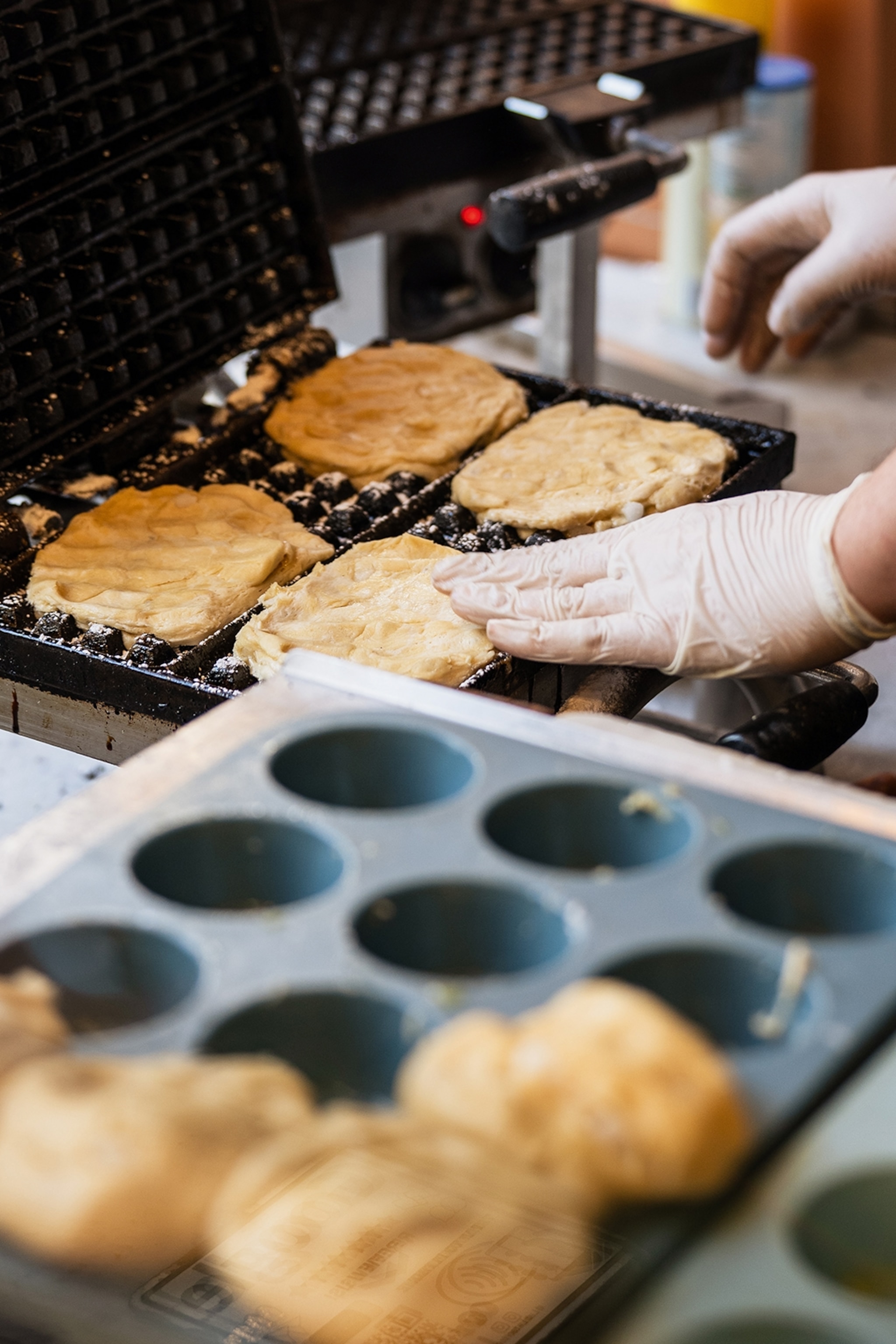 Waffles being prepared in a grill.