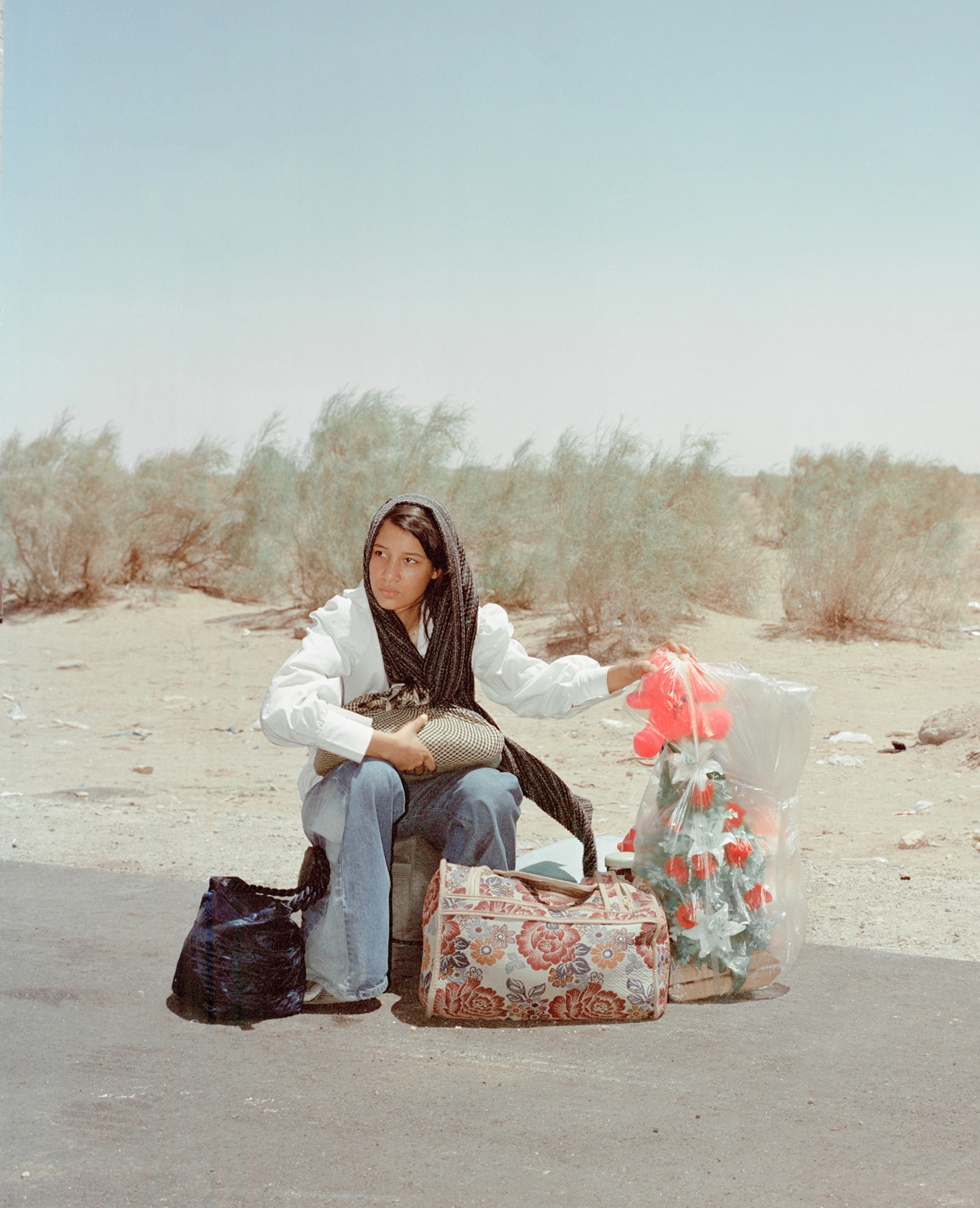 In the first half of 2025, nearly two million Afghan immigrants were deported from Pakistan and Iran. These forceful, at times violent, deportations are often triggered by geopolitical events that foster strong anti-migrant sentiments in the region. For 19-year-old Razia (pictured) and her family, Israel’s war with Iran led to her losing her adopted home in Iran, where she grew up and lived for many years after having escaped the war in Afghanistan. They were being accused, like many Afghans were, of being spies for Israel, an accusation that trickled down from the Iranian government and seeped into everyday interactions within the Iranian communities. Razia recalled increasing instances of insults at school and being denied food from charities simply for being Afghan. “Even close friends turned away from us,” she told Shakeri, while she sat at the border between Iran and Afghanistan, resting on the pile of a few meager belongings that her family was able to bring with them. After having received orders from the Iranian government to leave the country, Razia looked toward an uncertain future in a country where women’s identities mean little. “I really don’t know what awaits me and my sisters.”