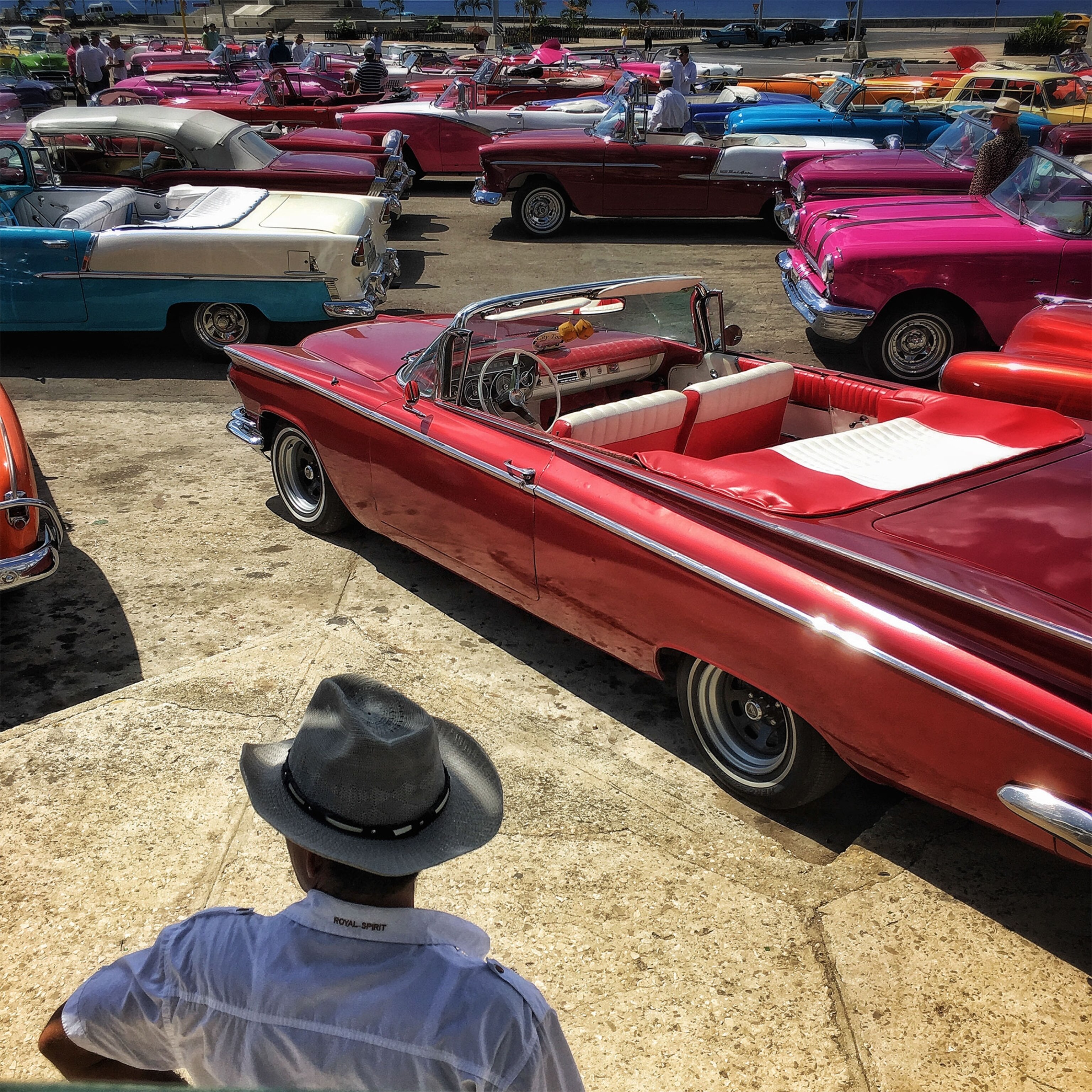 a man standing near old cars in Havana, Cuba