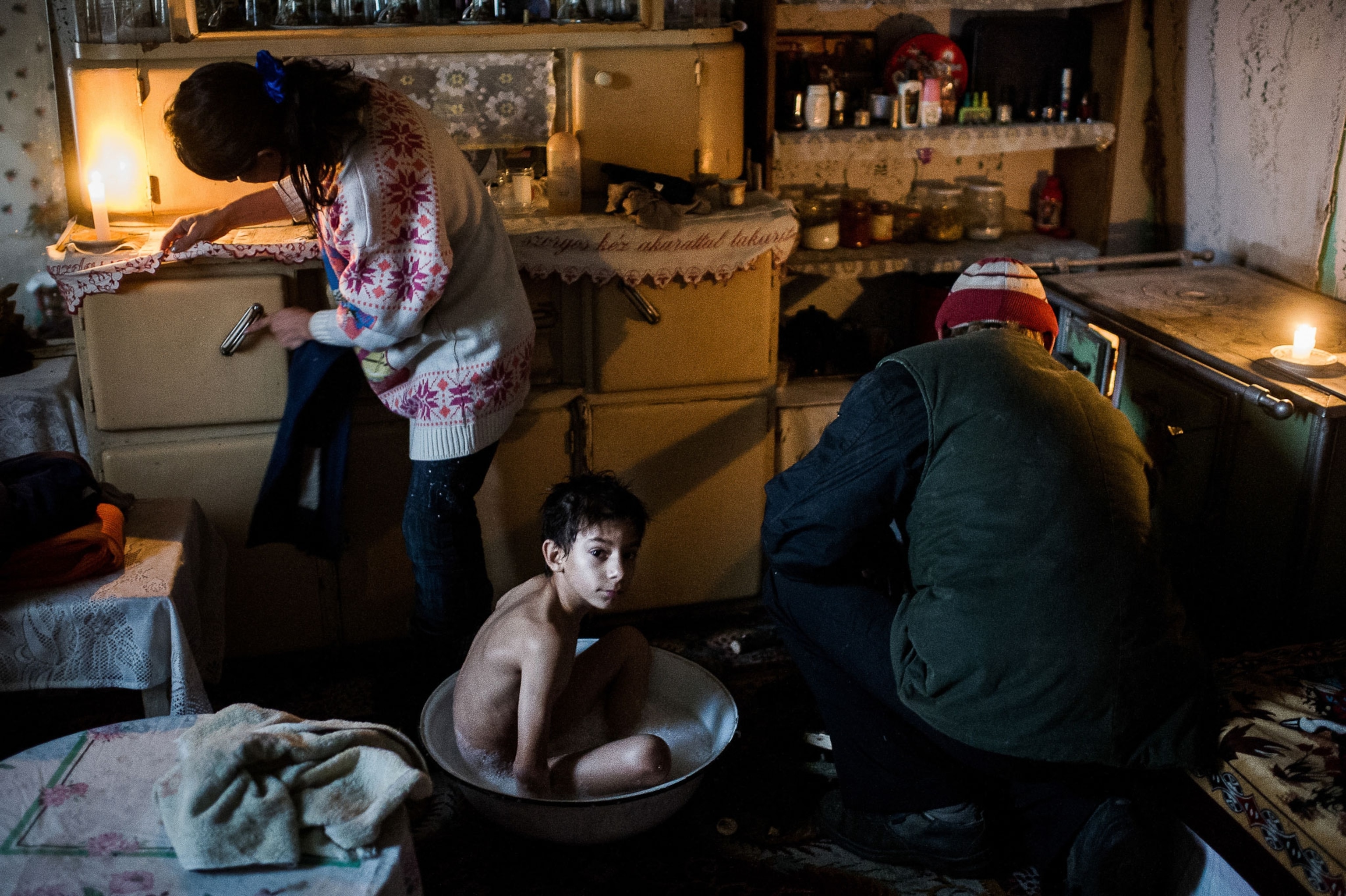 With no bathroom to speak of, Sanyi Székely takes a bath each night in a basin. As their farm near Nyársapát lacks electricity, he does his homework by candlelight.
