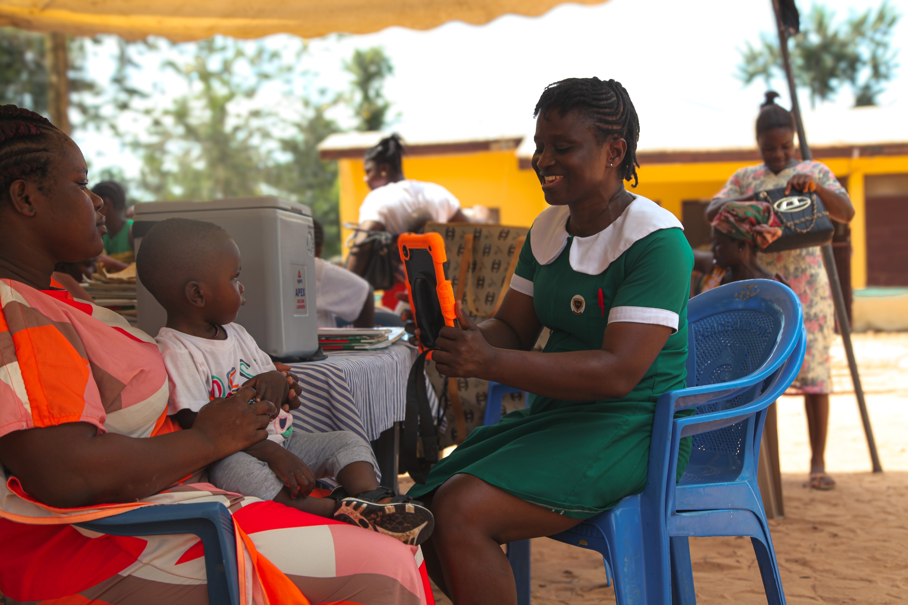 A nurse using a tablet loaded with SimprintsID to capture biometric modalities that will form the basis of a child’s medical ID.
