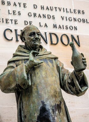 A bronze statue of Dom P&eacute;rignon stands in front of bronze lettering in &Eacute;pernay.