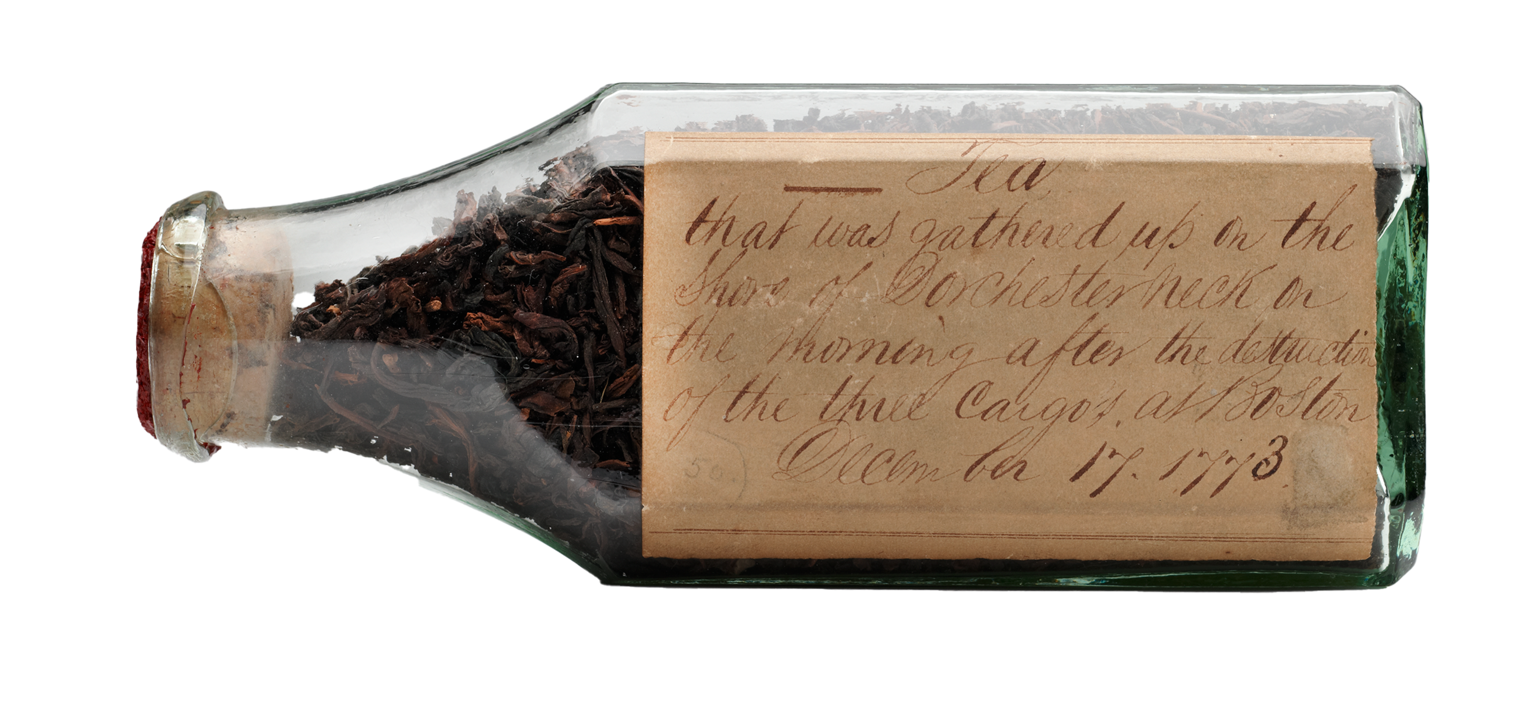 A bottle filled with dried up leaves and a note.