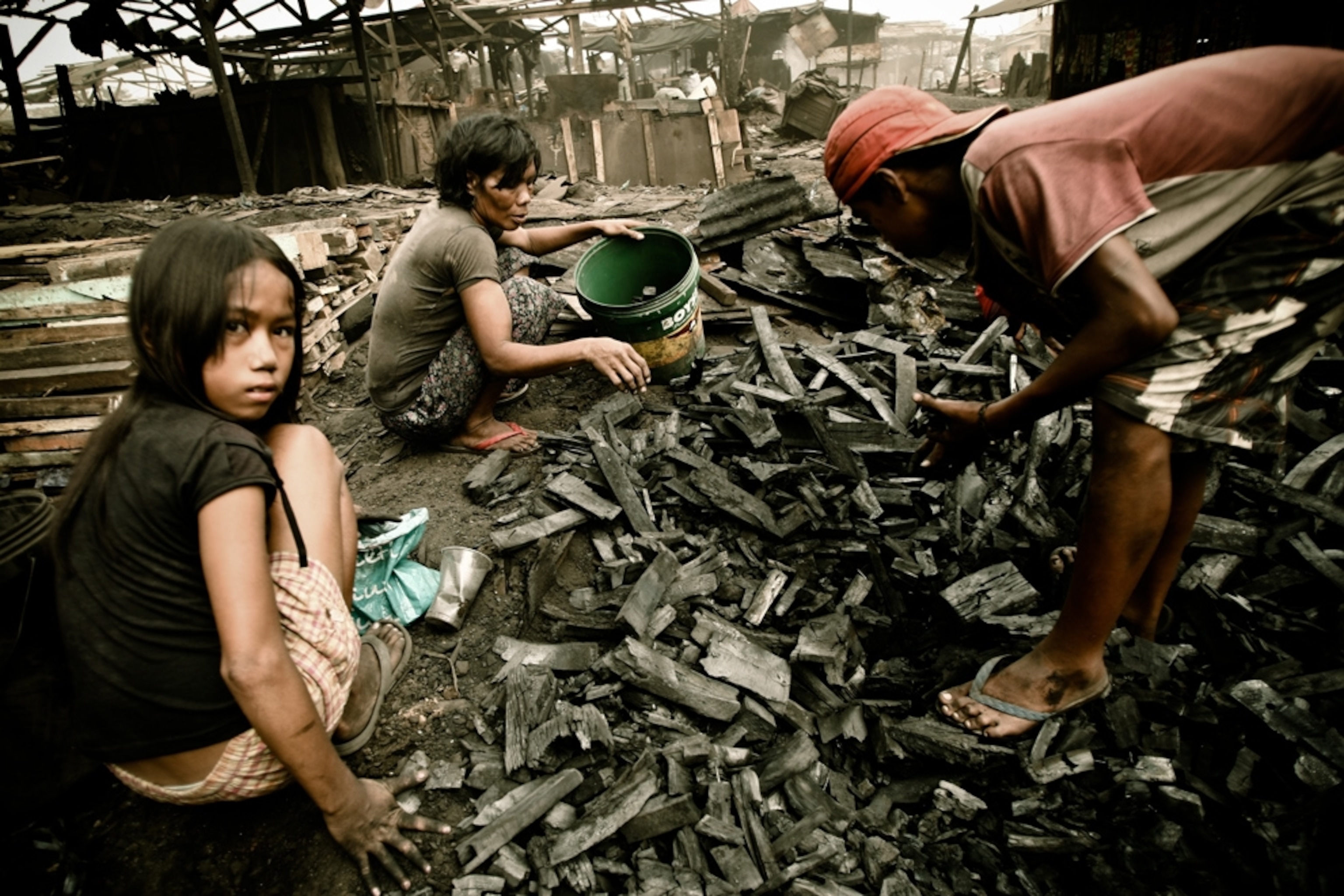 Children gather charcoal to sell in Manila's slums