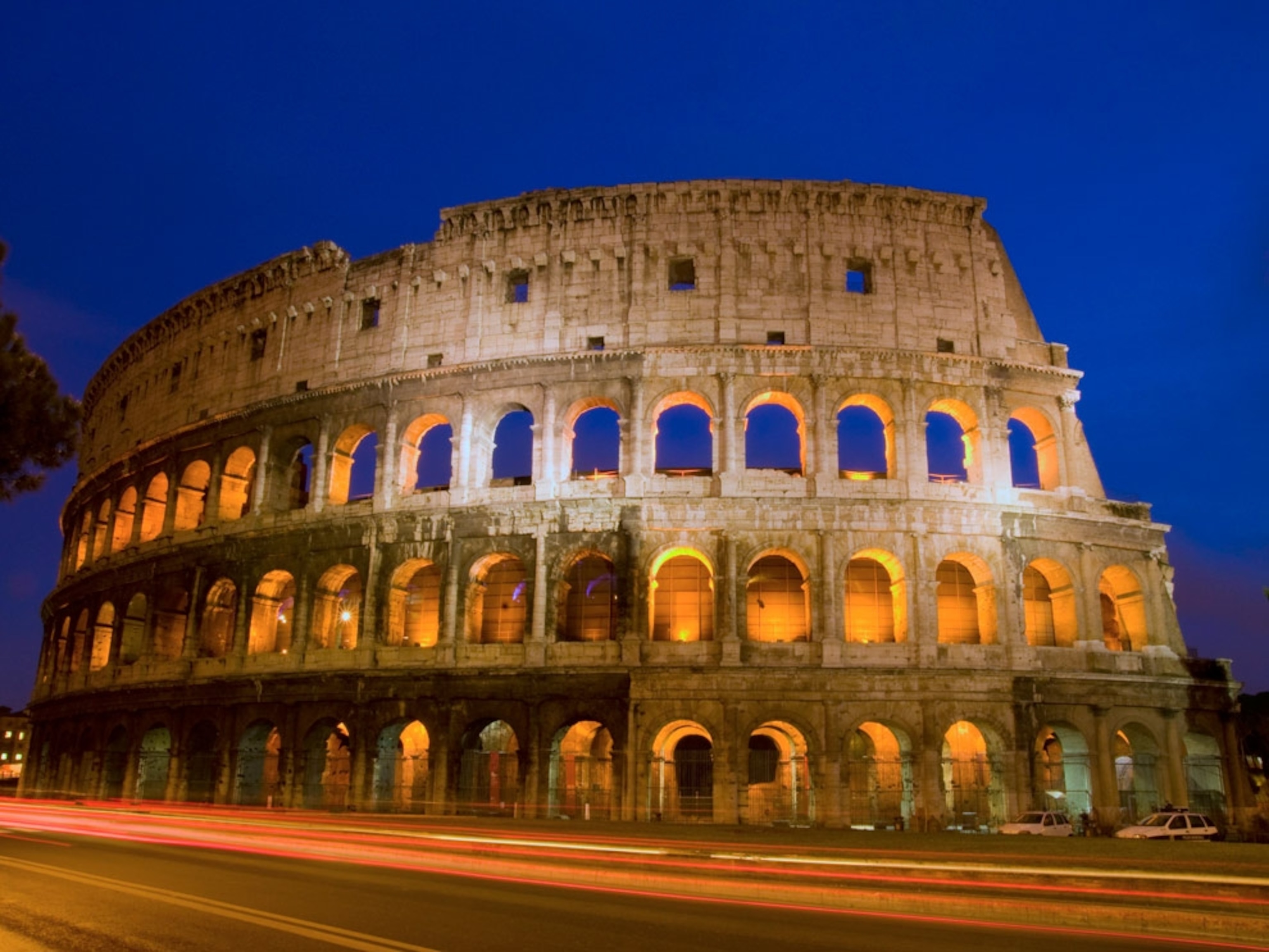 Lights casting a glow on the Colosseum at night
