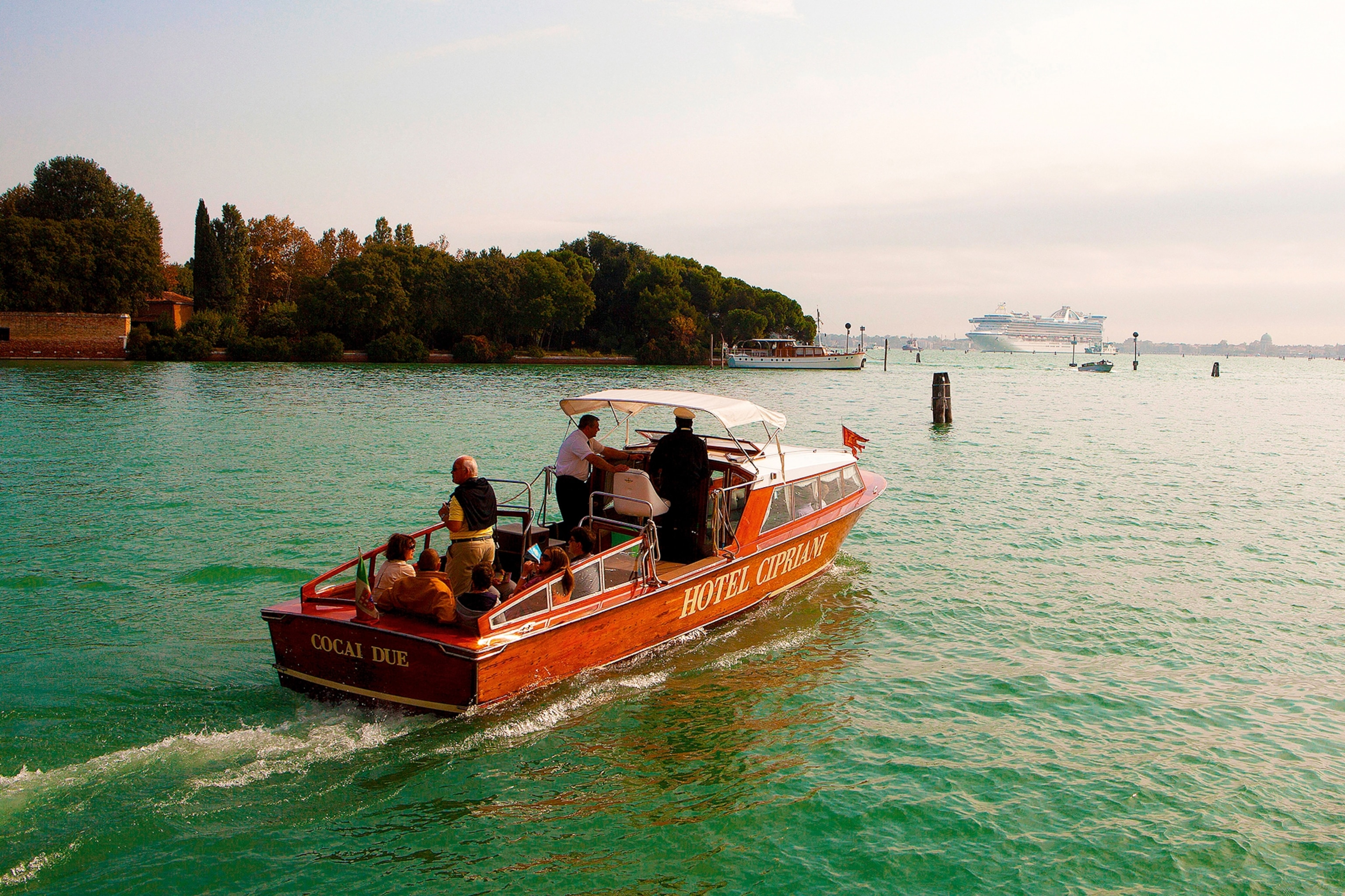 A luxurious boat on a canal in Venice heading out towards the sea.